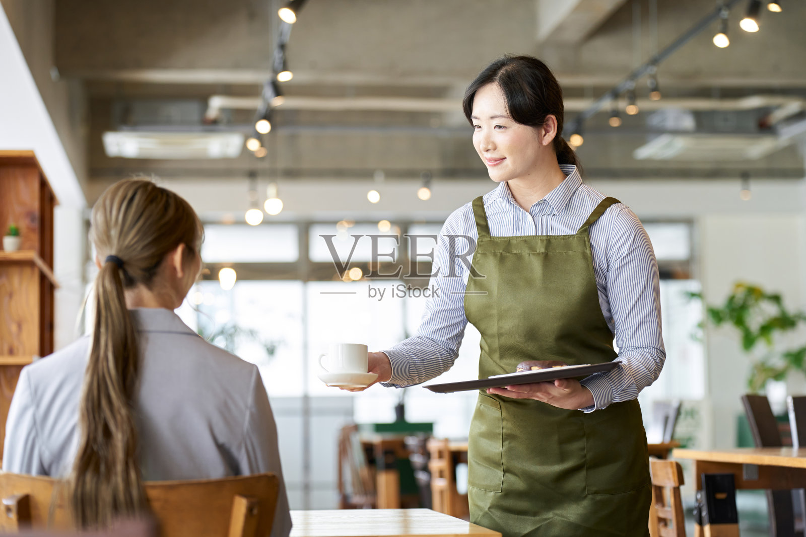 在餐厅拿着零食的亚洲员工照片摄影图片