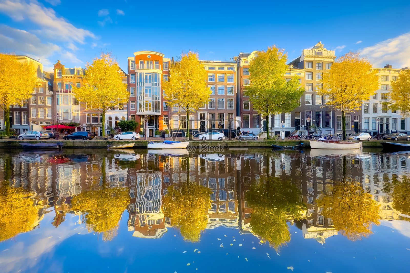 阿姆斯特丹的秋天。荷兰首都。老房子和运河的景色。在水面上的反射。树上的黄叶。明信片、背景或壁纸。照片摄影图片