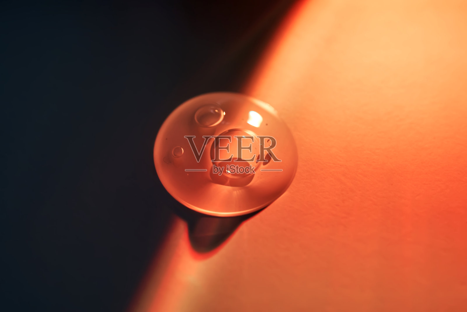 在橘黄色的夕阳下滴下一滴防晒乳。照片摄影图片