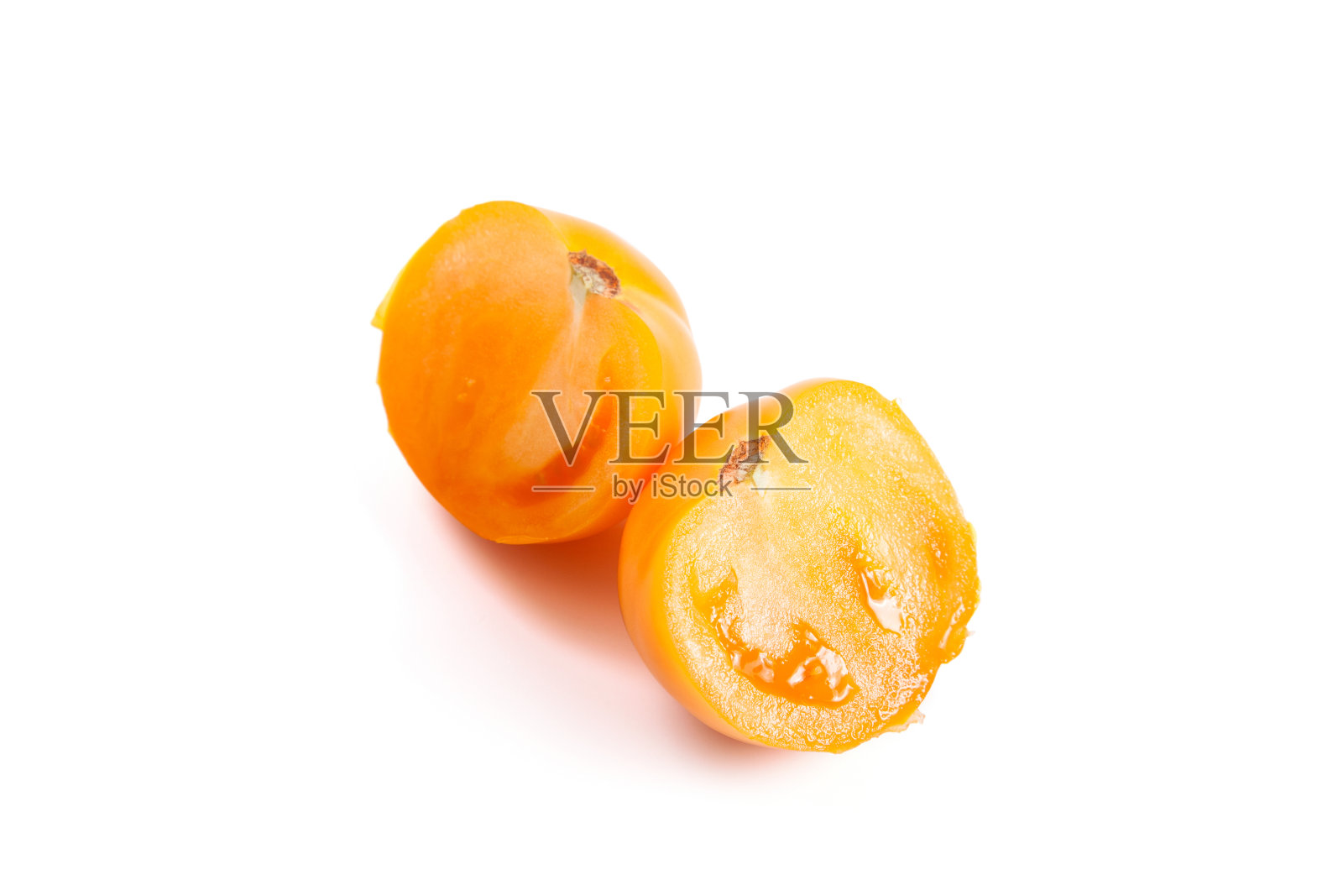 在白色背景上分离的黄色番茄的两半照片摄影图片