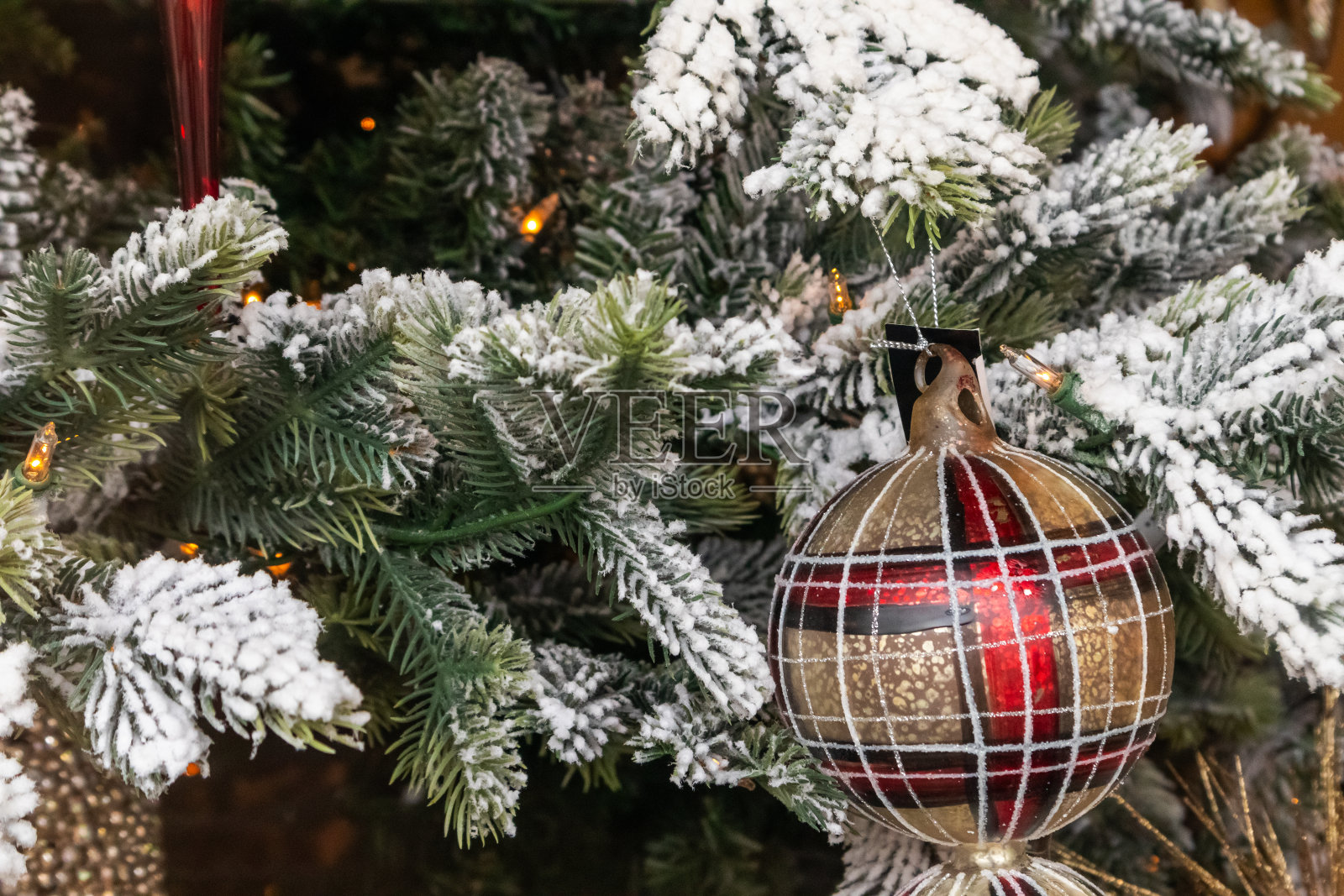 圣诞树上的雪枝上有格子装饰照片摄影图片