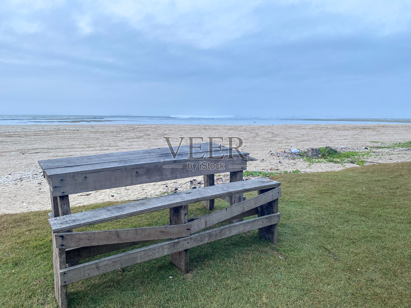 沙滩边草地上的长凳桌子照片摄影图片