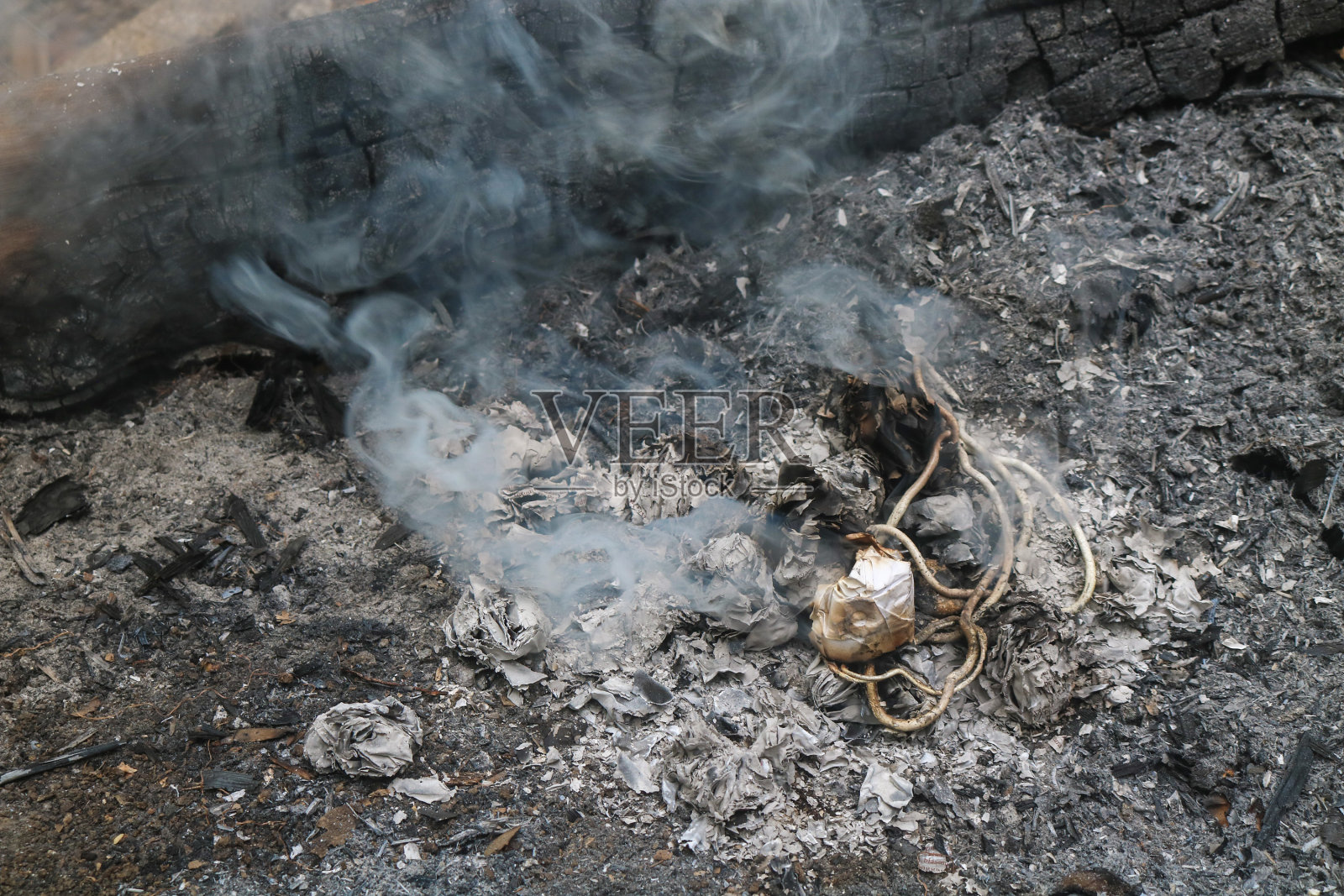 在地上焚烧塑料和废纸。垃圾燃烧产生的烟和灰照片摄影图片