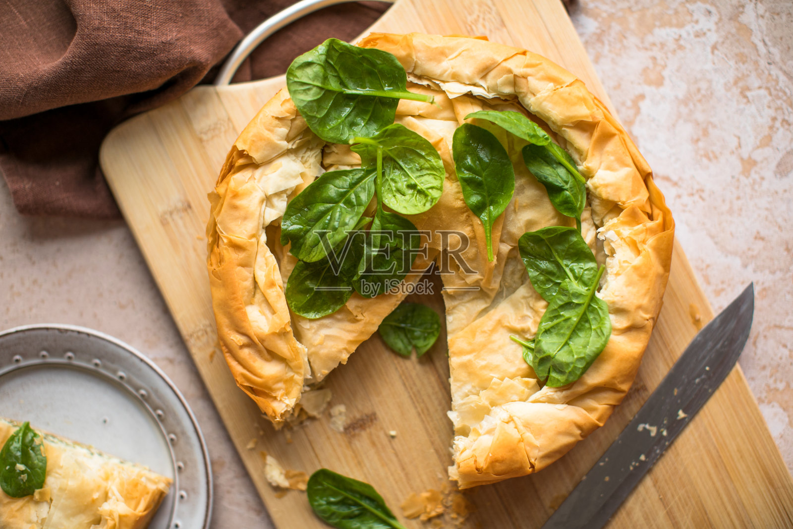 希腊派菠菜和奶酪木板。黑暗的背景。俯视图照片摄影图片