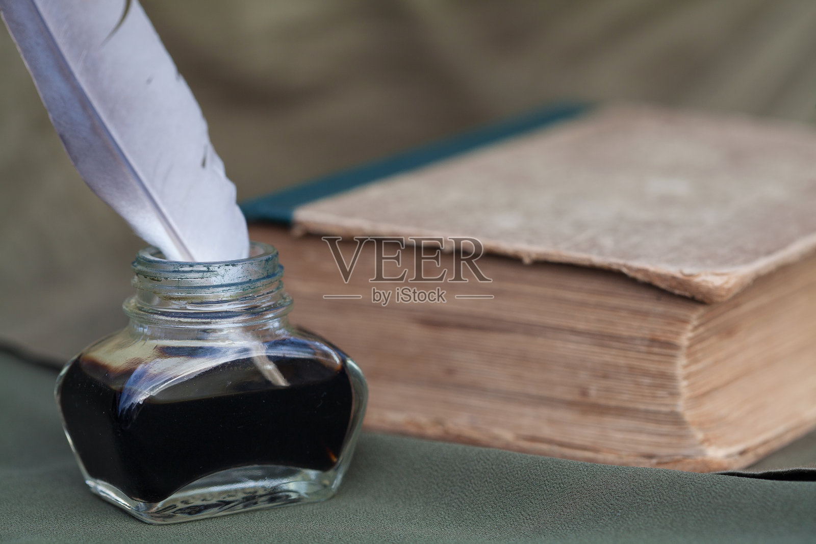 静物与一个老式墨水瓶，一支羽毛笔和一本旧书照片摄影图片