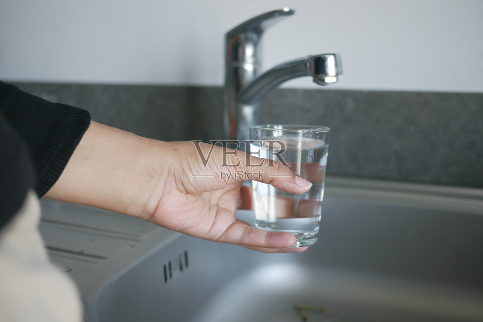 水从水龙头倒在玻璃杯里，喝纯净水的概念照片摄影图片