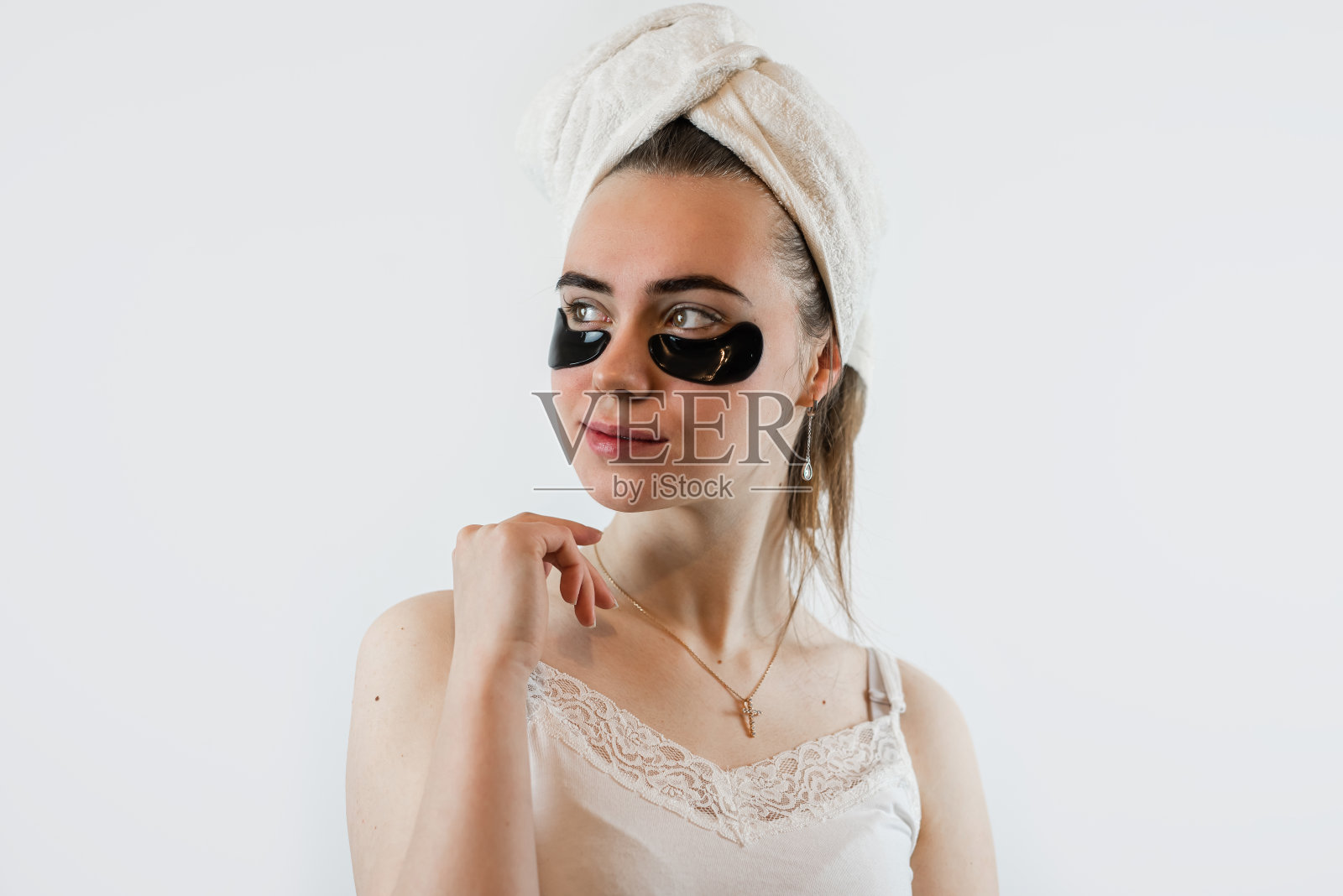 年轻迷人的白人妇女接受抗皱治疗，黑眼罩隔离在白色照片摄影图片