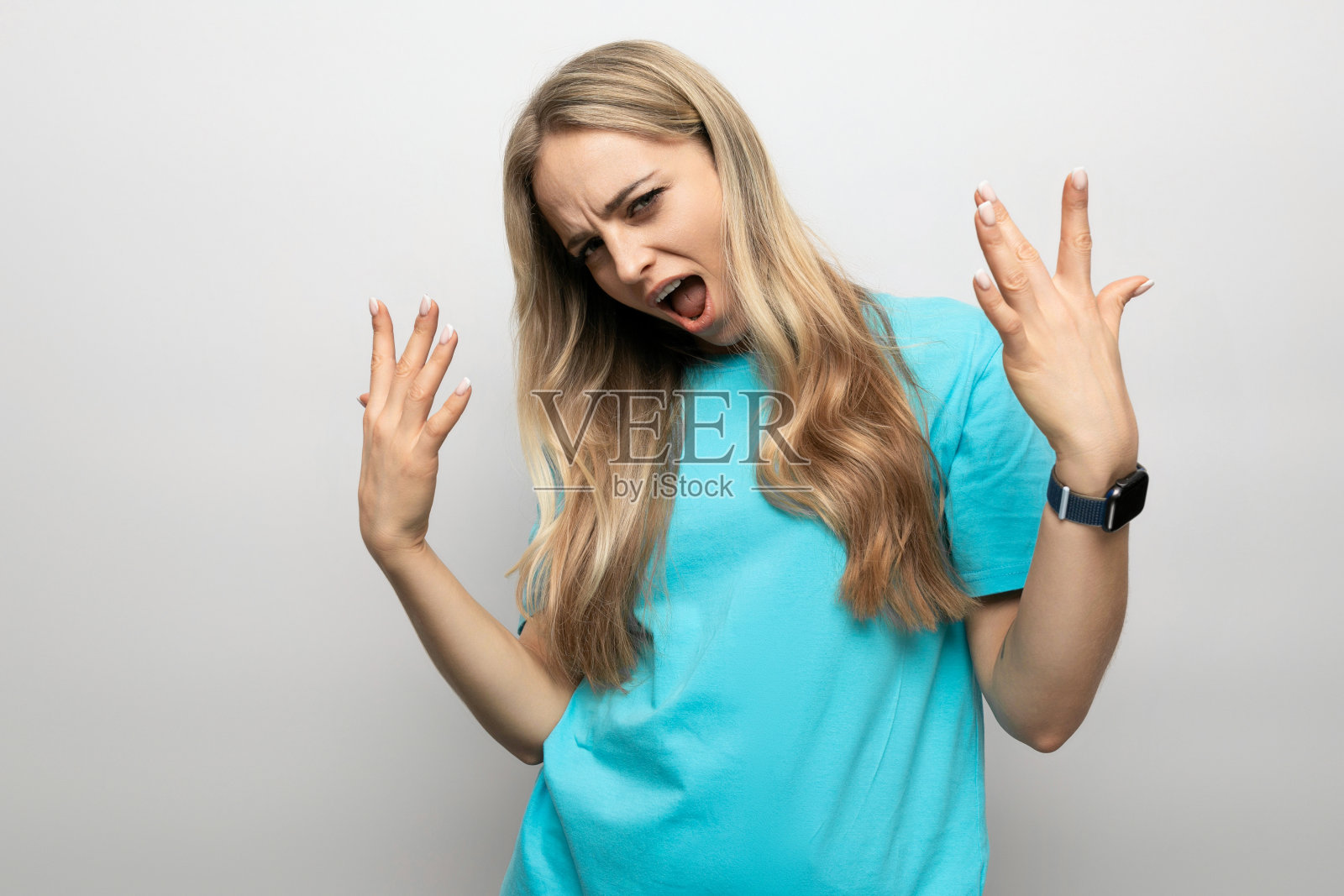 女孩在工作室的白色背景上做鬼脸照片摄影图片