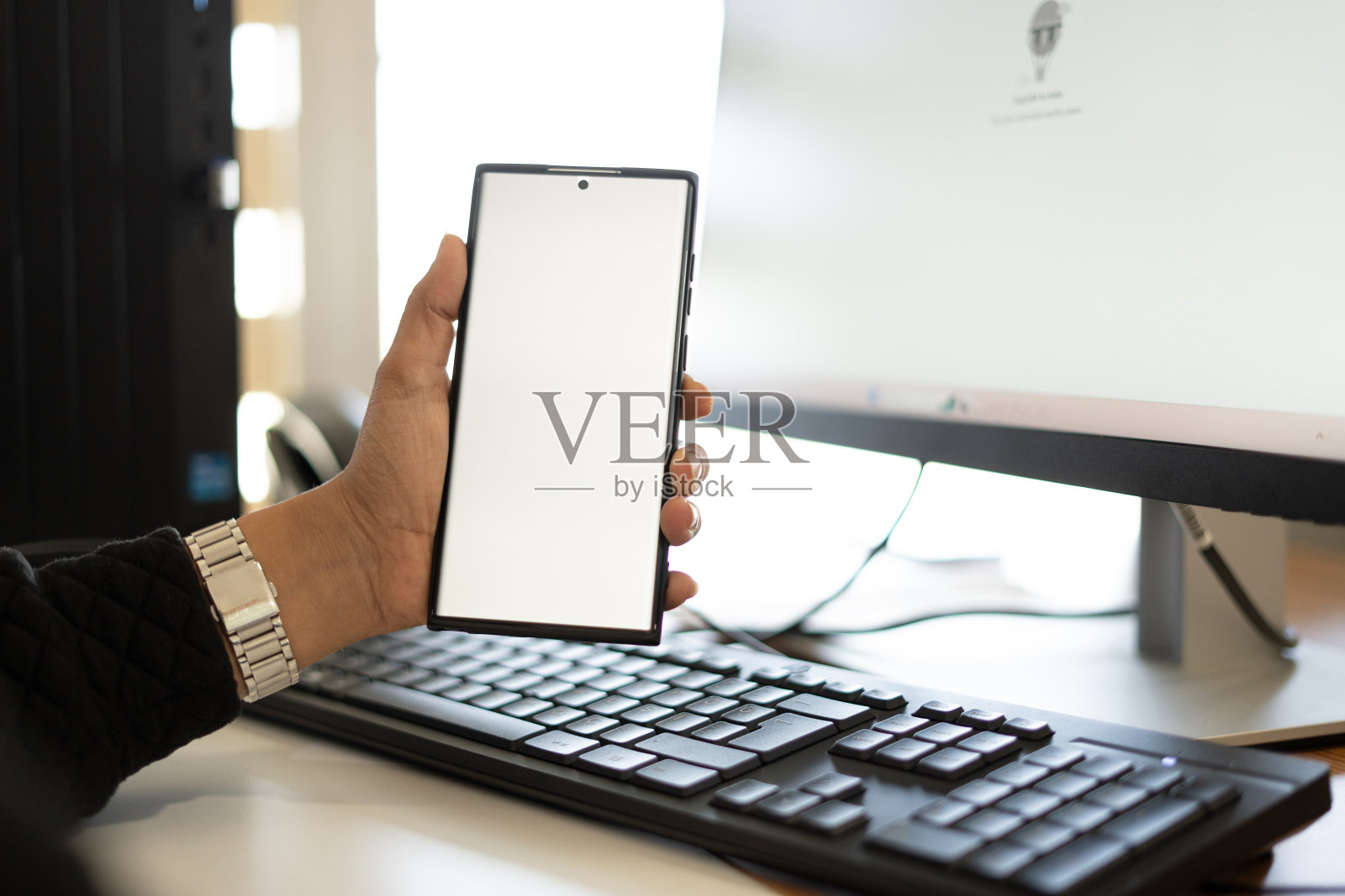 (特写)女士在办公室里拿着白屏手机照片摄影图片