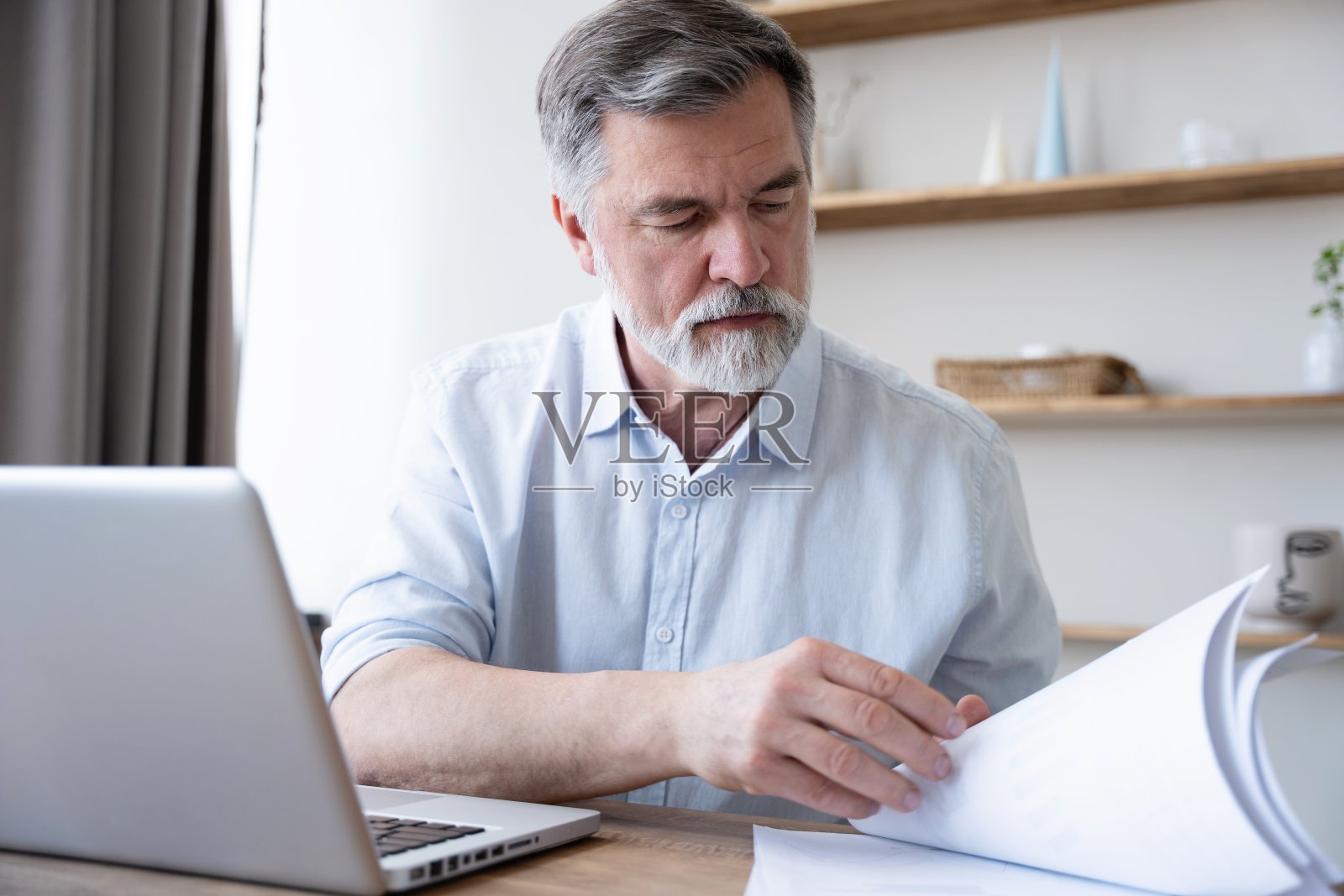一个人在家用笔记本电脑工作。统计财务数据。照片摄影图片