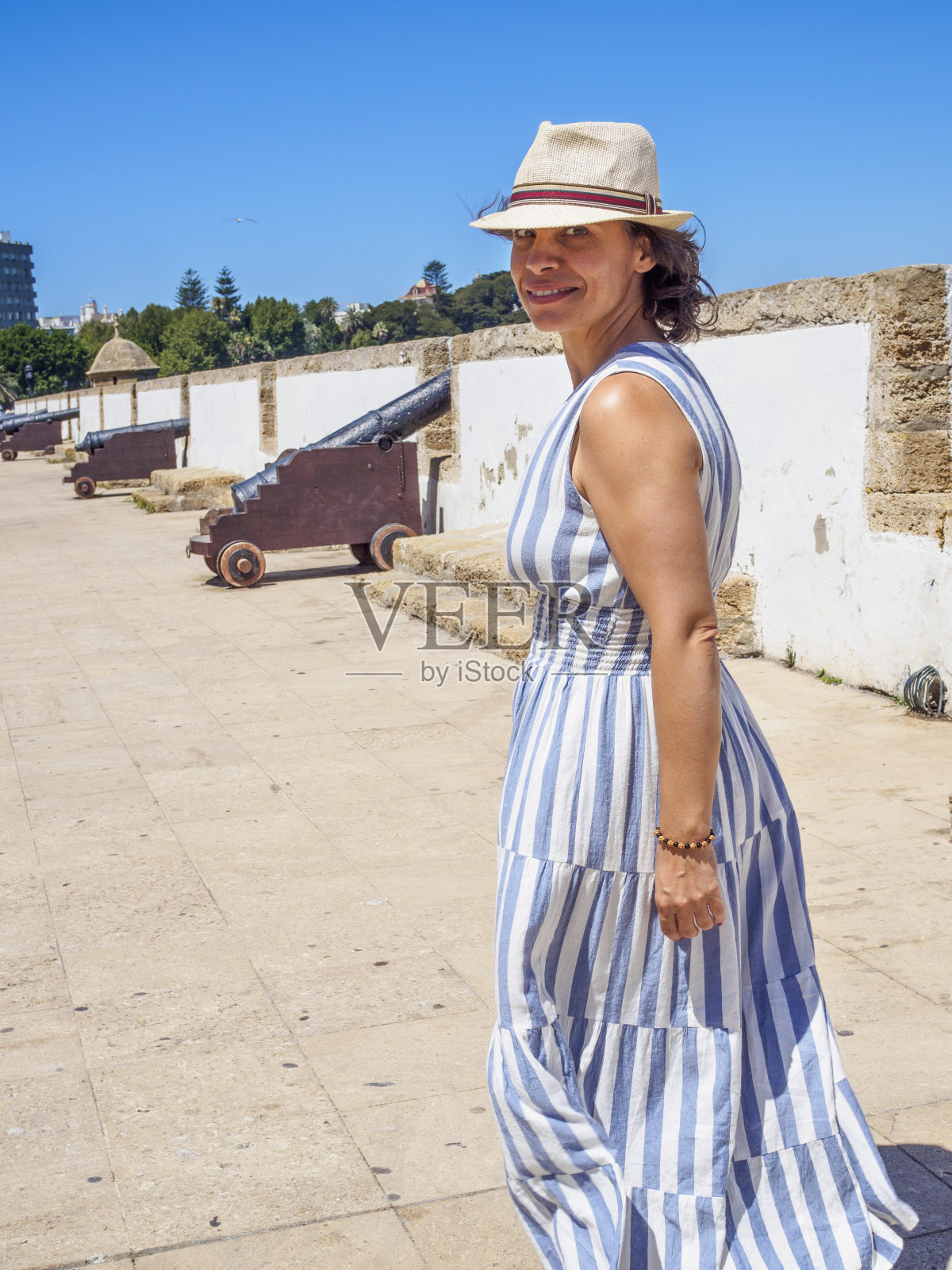 一个白人妇女走在古色古香的拉丁美洲海滨长廊上。照片摄影图片