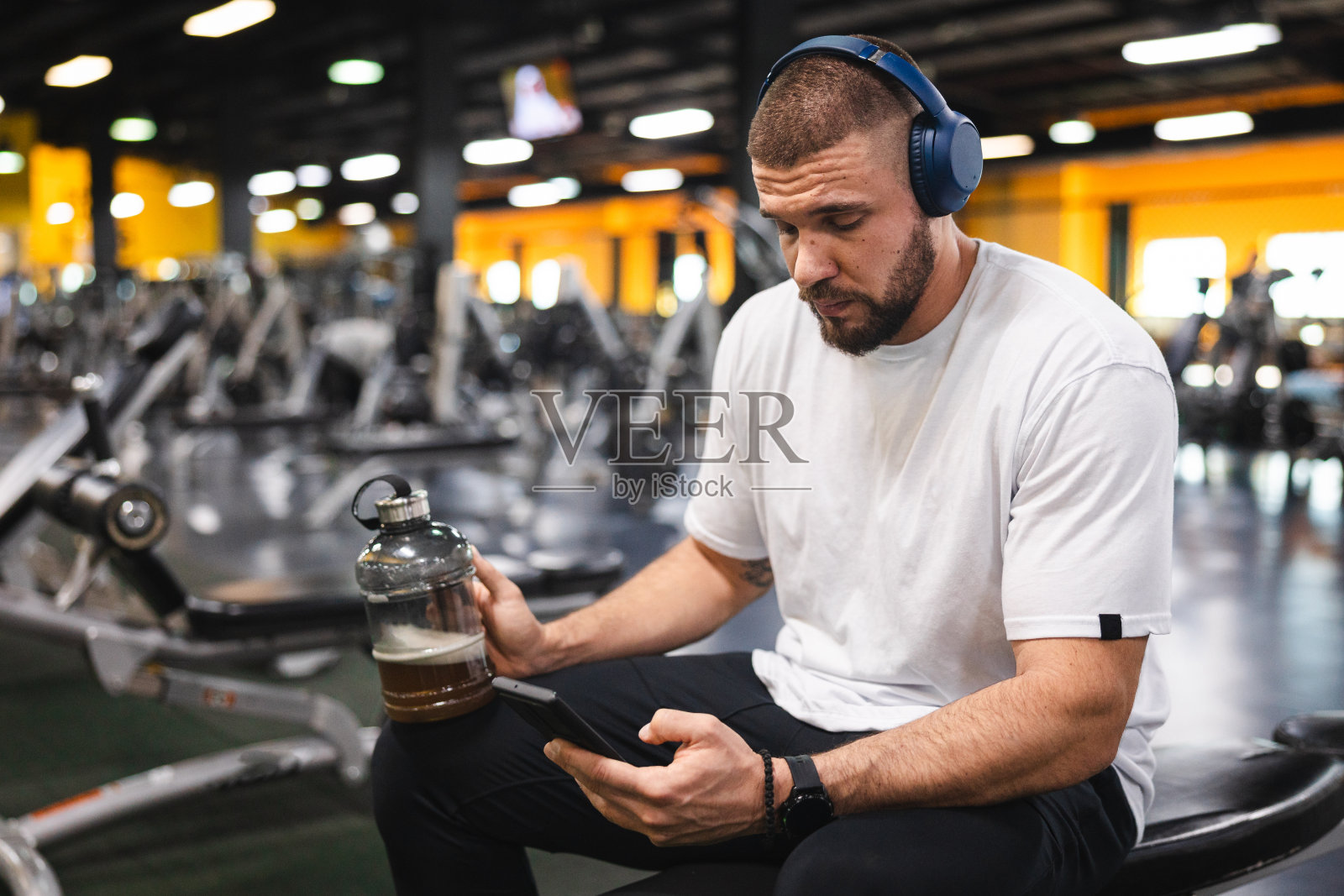 年轻男人喝着蛋白奶昔，为锻炼做准备照片摄影图片