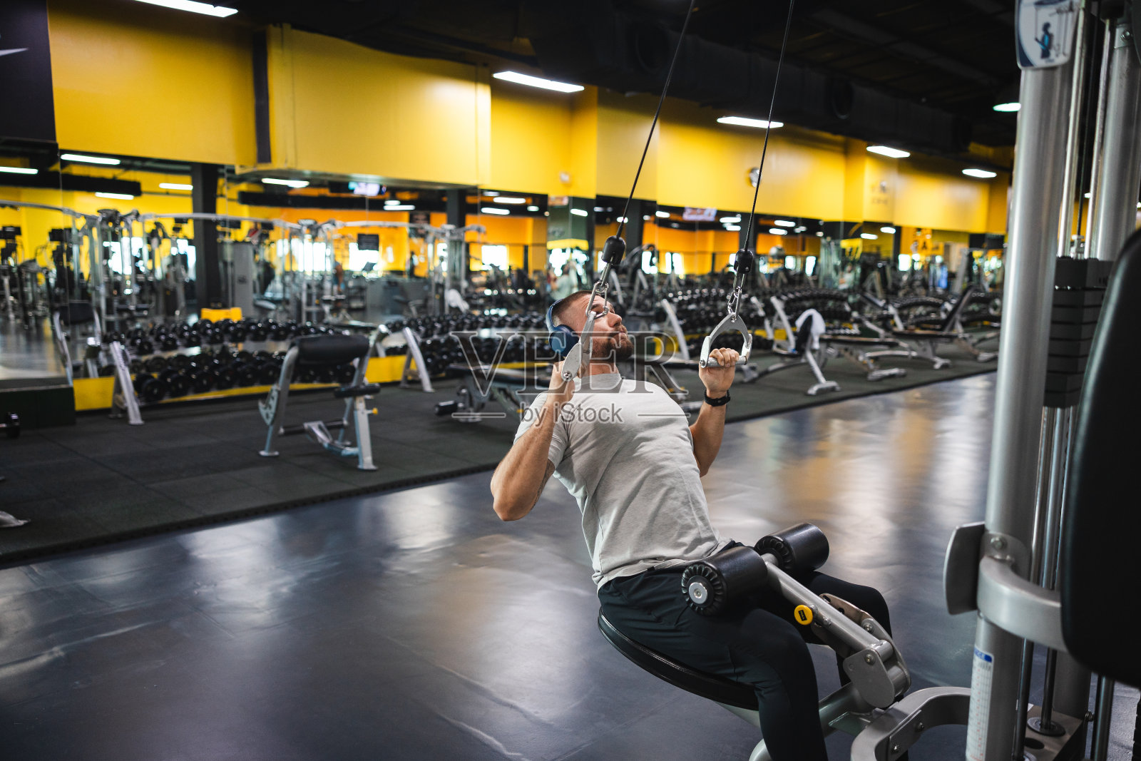 年轻男人在健身房拉动缆绳照片摄影图片
