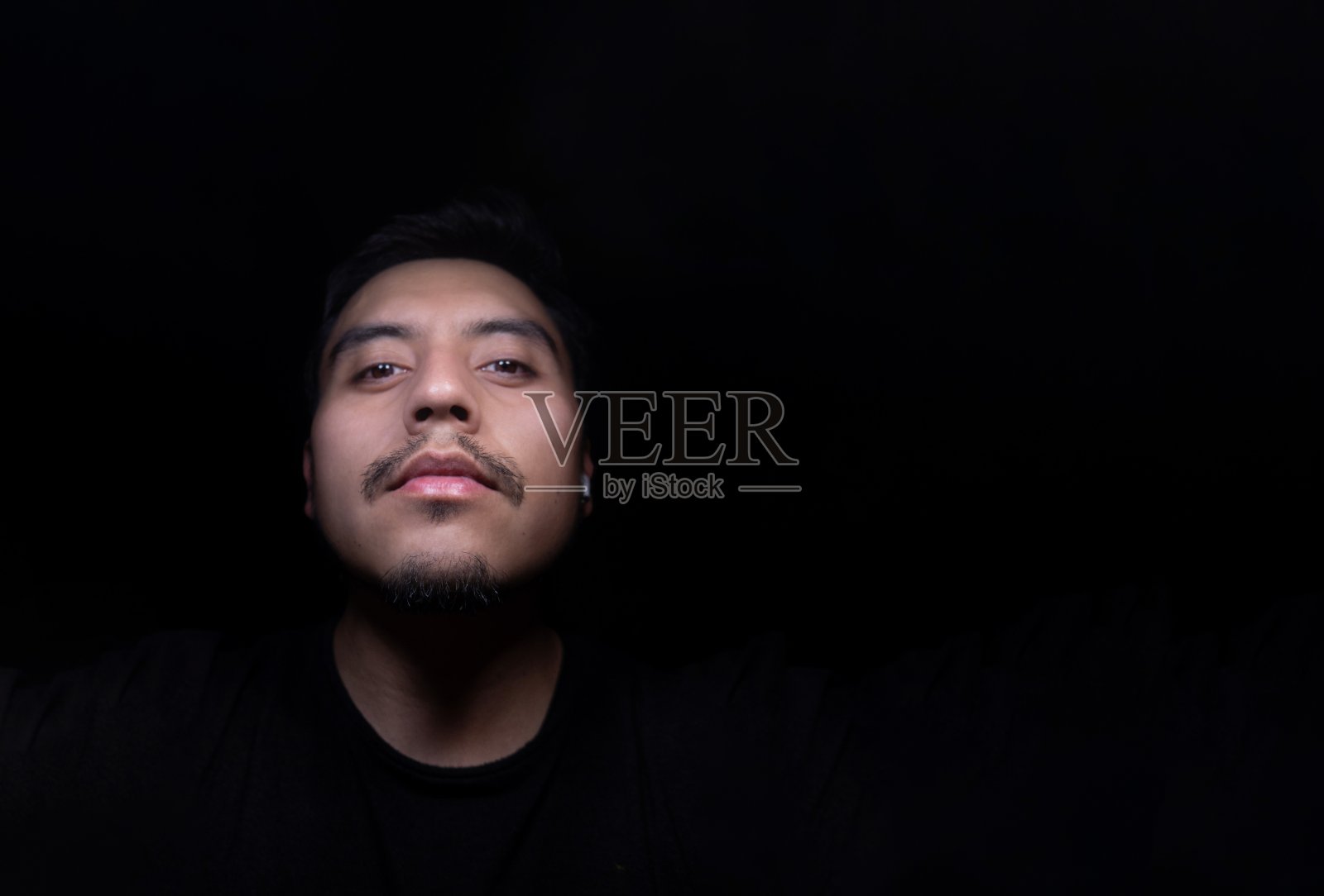 拉丁人的脸，黑色背景，右边留出文字空间照片摄影图片