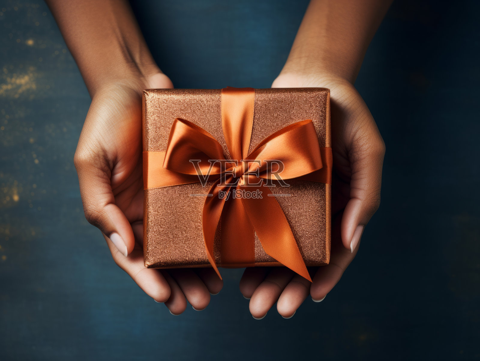 女人手拿着礼物与金丝带蝴蝶结在蓝色背景照片摄影图片