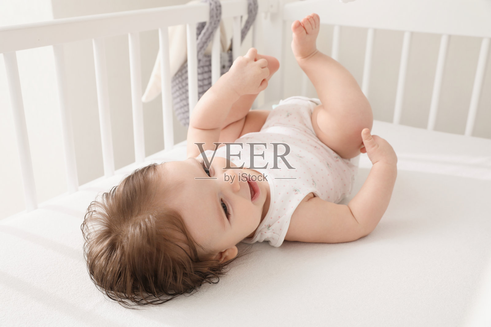 可爱的小婴儿躺在舒适的婴儿床在家里照片摄影图片