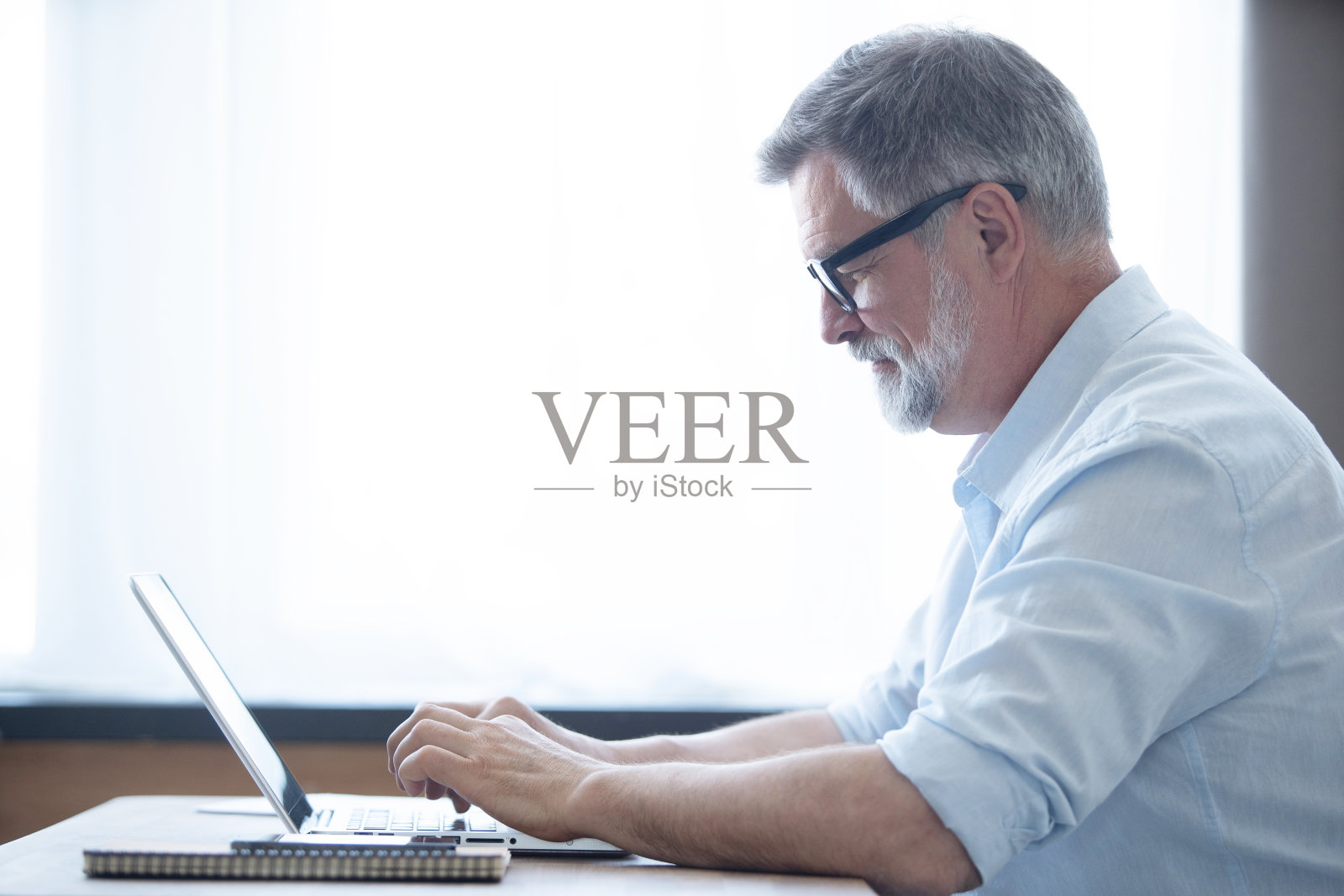 成熟的商人在家里用笔记本电脑工作照片摄影图片