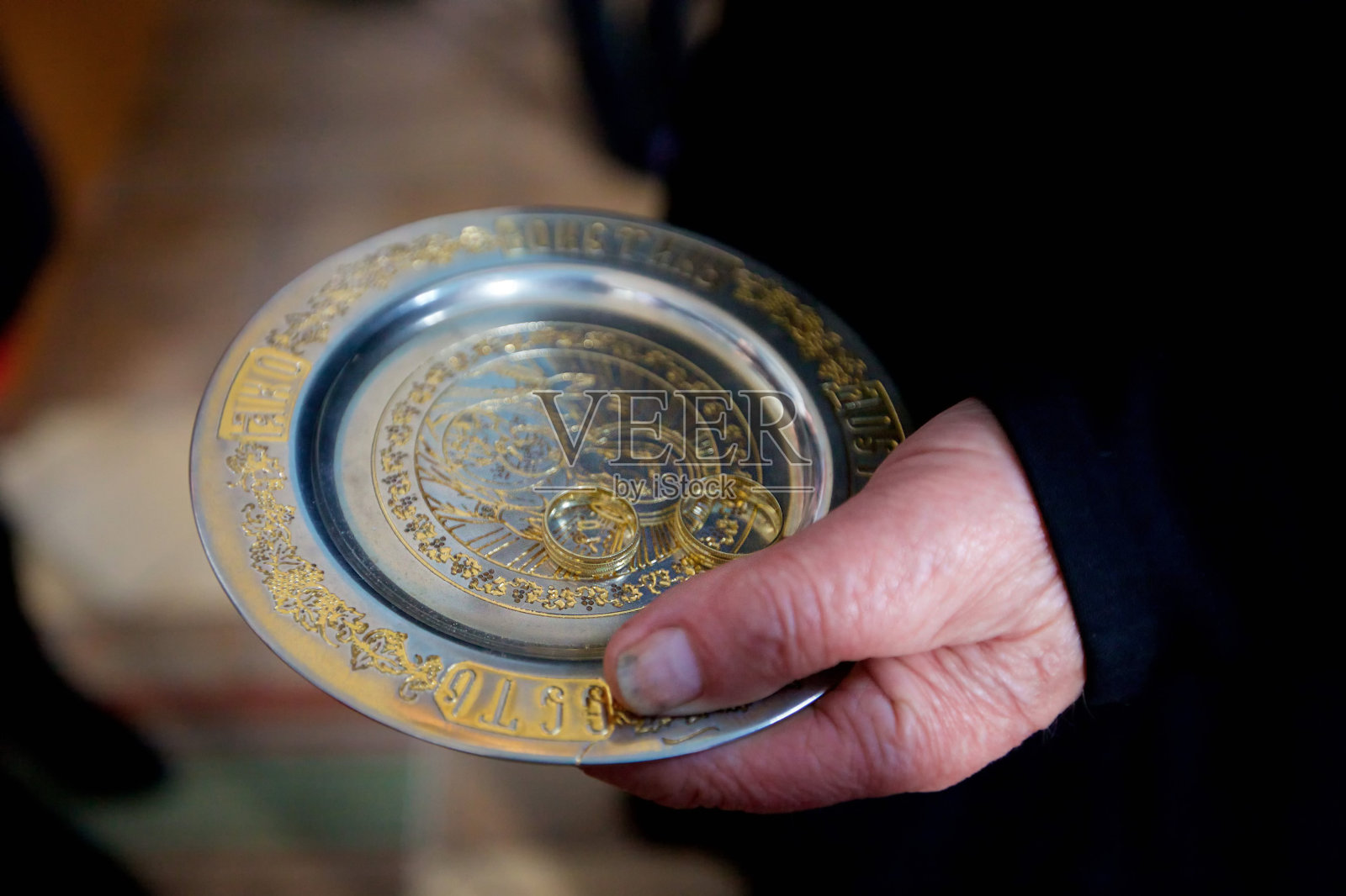 一位基督教牧师手里拿着结婚戒指。照片摄影图片