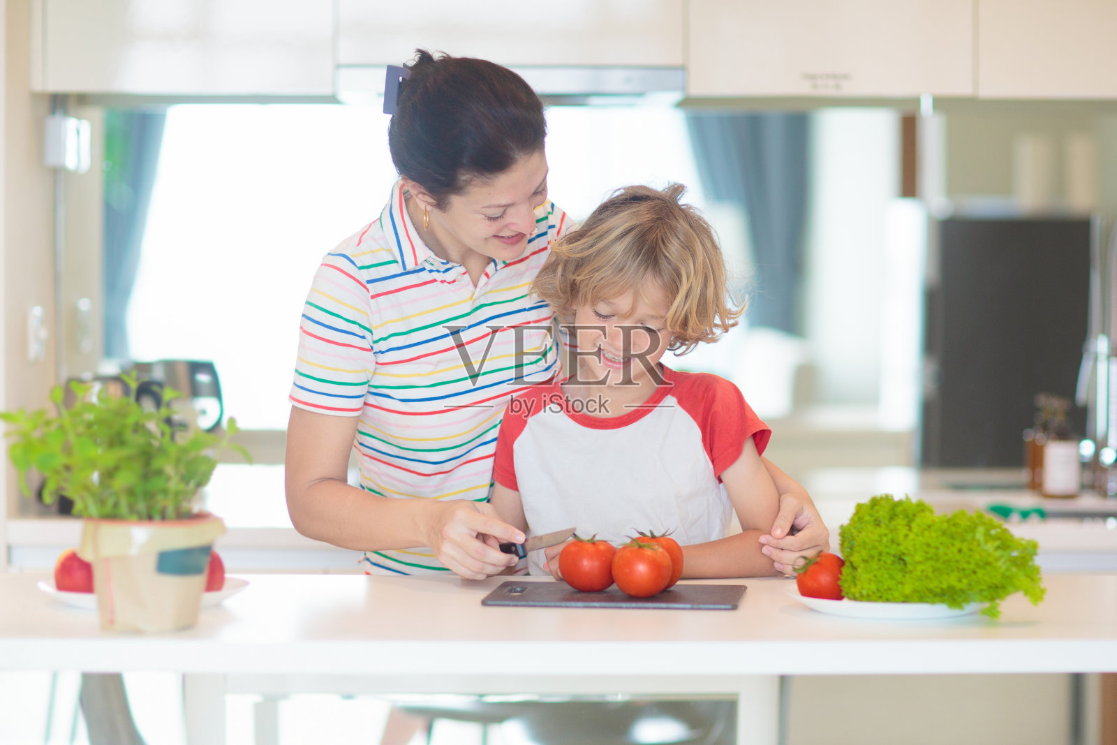 家庭烹饪晚餐，妈妈和孩子做饭照片摄影图片