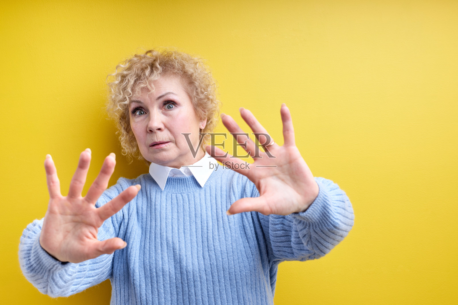 高级美女穿着优雅的衣服站在孤立的黄色背景上拒绝的表情照片摄影图片