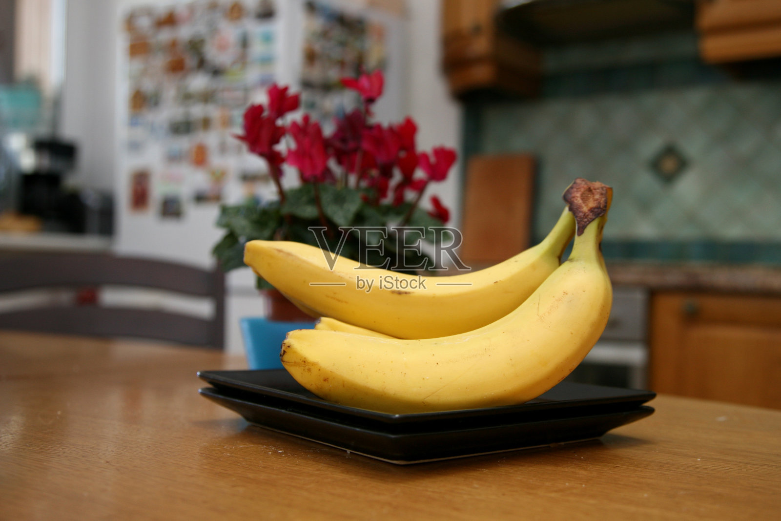 一串香蕉躺在结实的厨房桌子上。甜熟的香蕉，黄皮。厨房里的香蕉和混合水果照片摄影图片