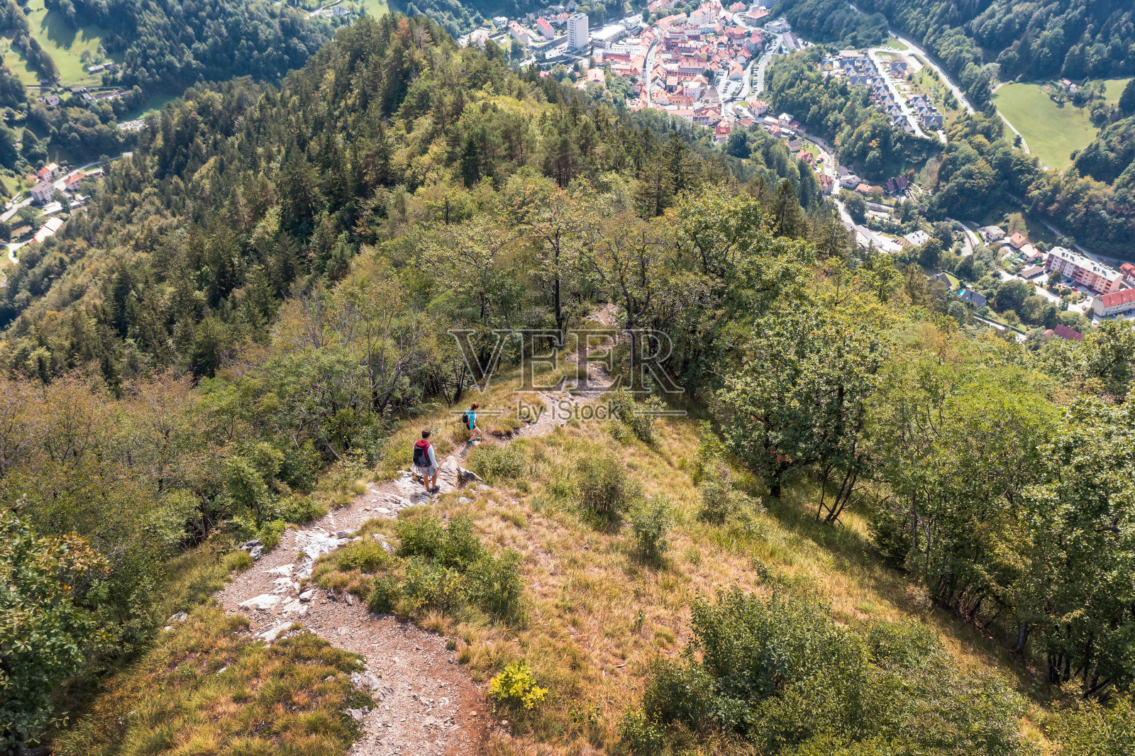 两个人在下山的路上，徒步穿过树林的小路，空中照片摄影图片