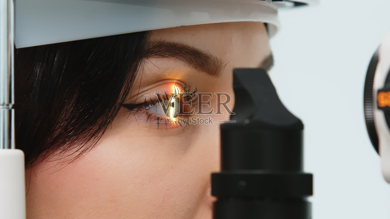 一位年轻女性在眼科诊断视力测试设备上进行视力测试的特写。专业眼科仪器。照片摄影图片