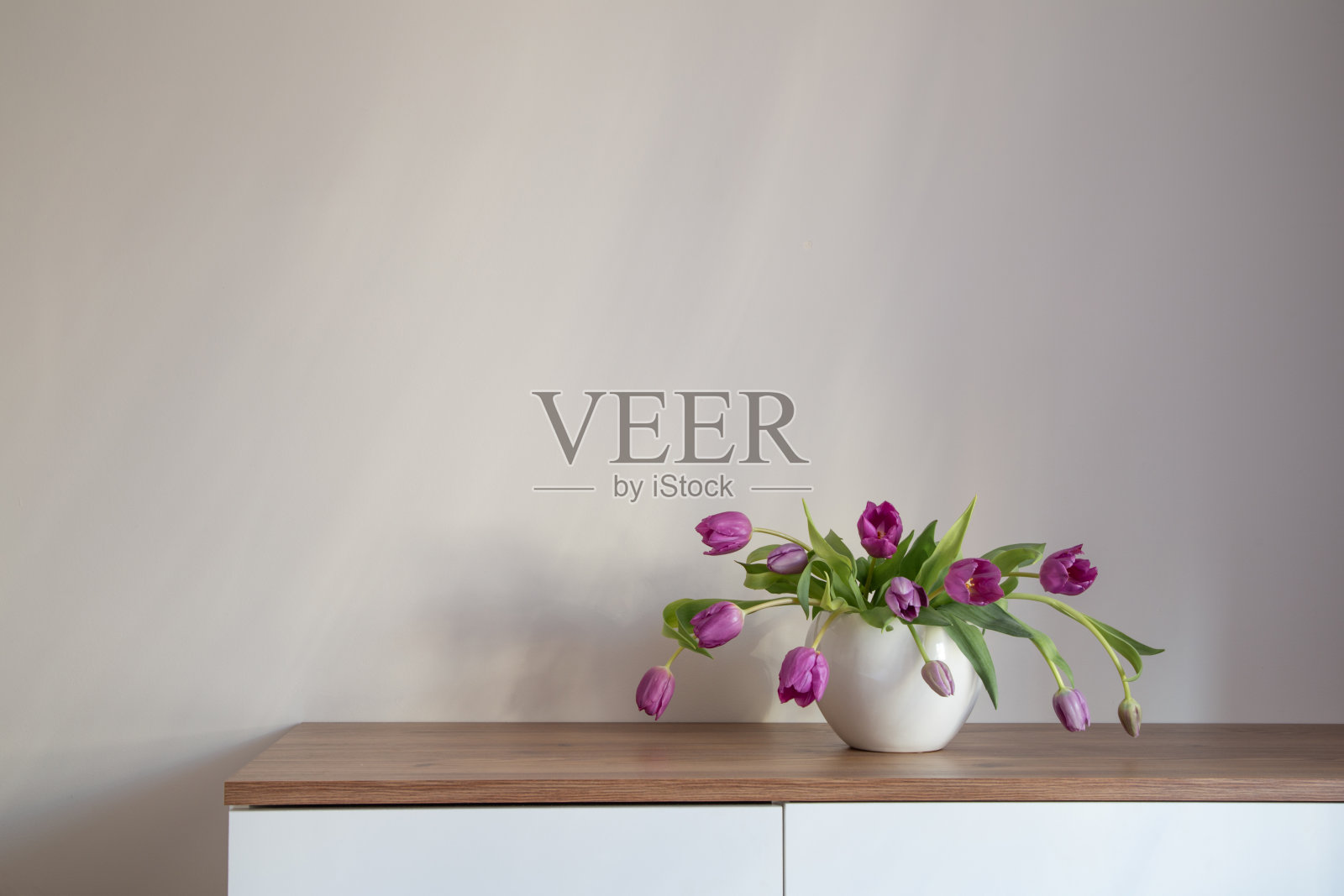 紫色郁金香在白色陶瓷花瓶在木架子上照片摄影图片