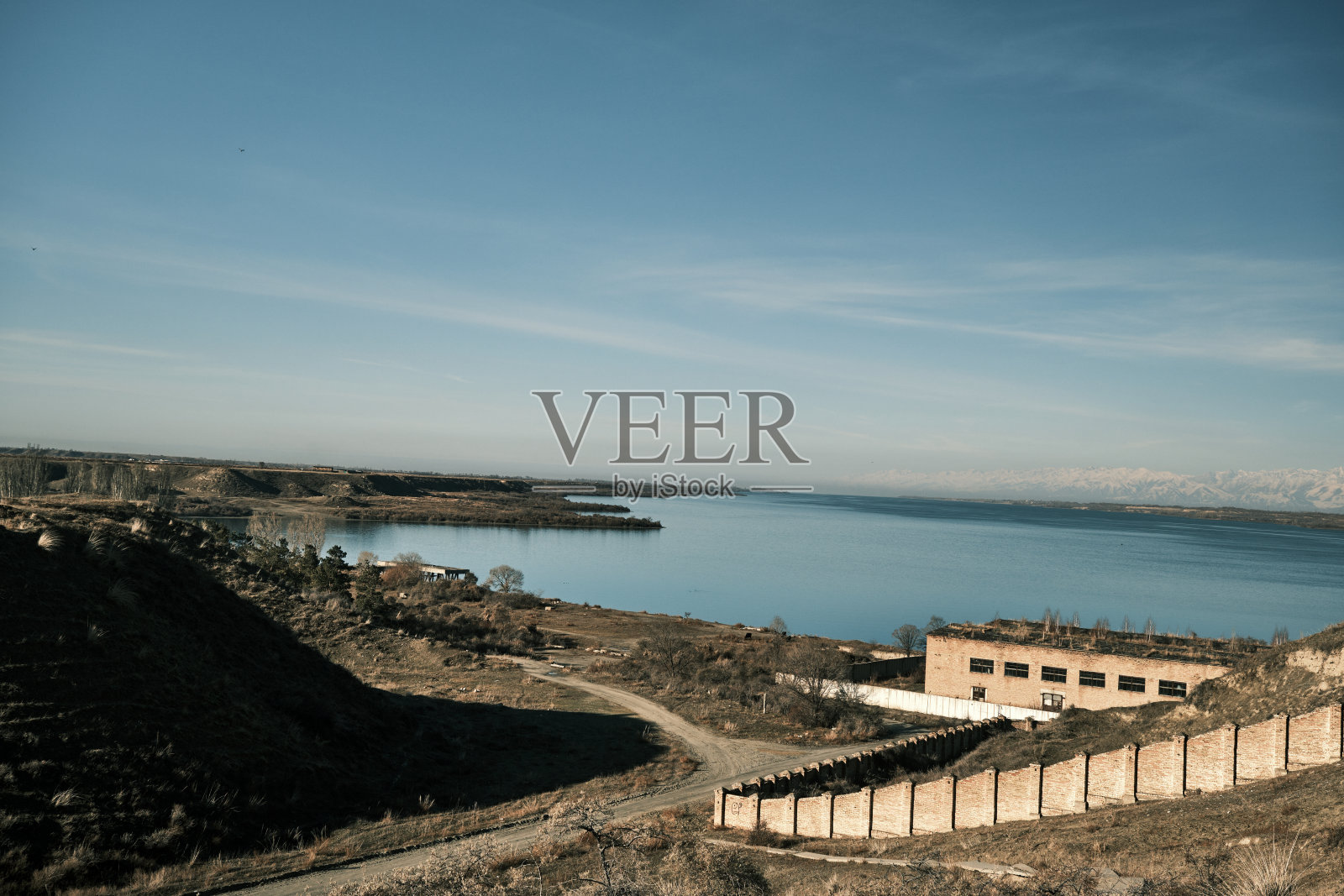 深秋的伊塞克湖的老码头和北岸的山脊照片摄影图片