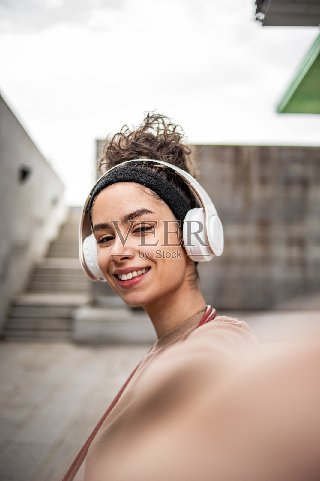 一名年轻女运动员在水泥墙旁自拍，结束了她跳绳的运动训练照片摄影图片