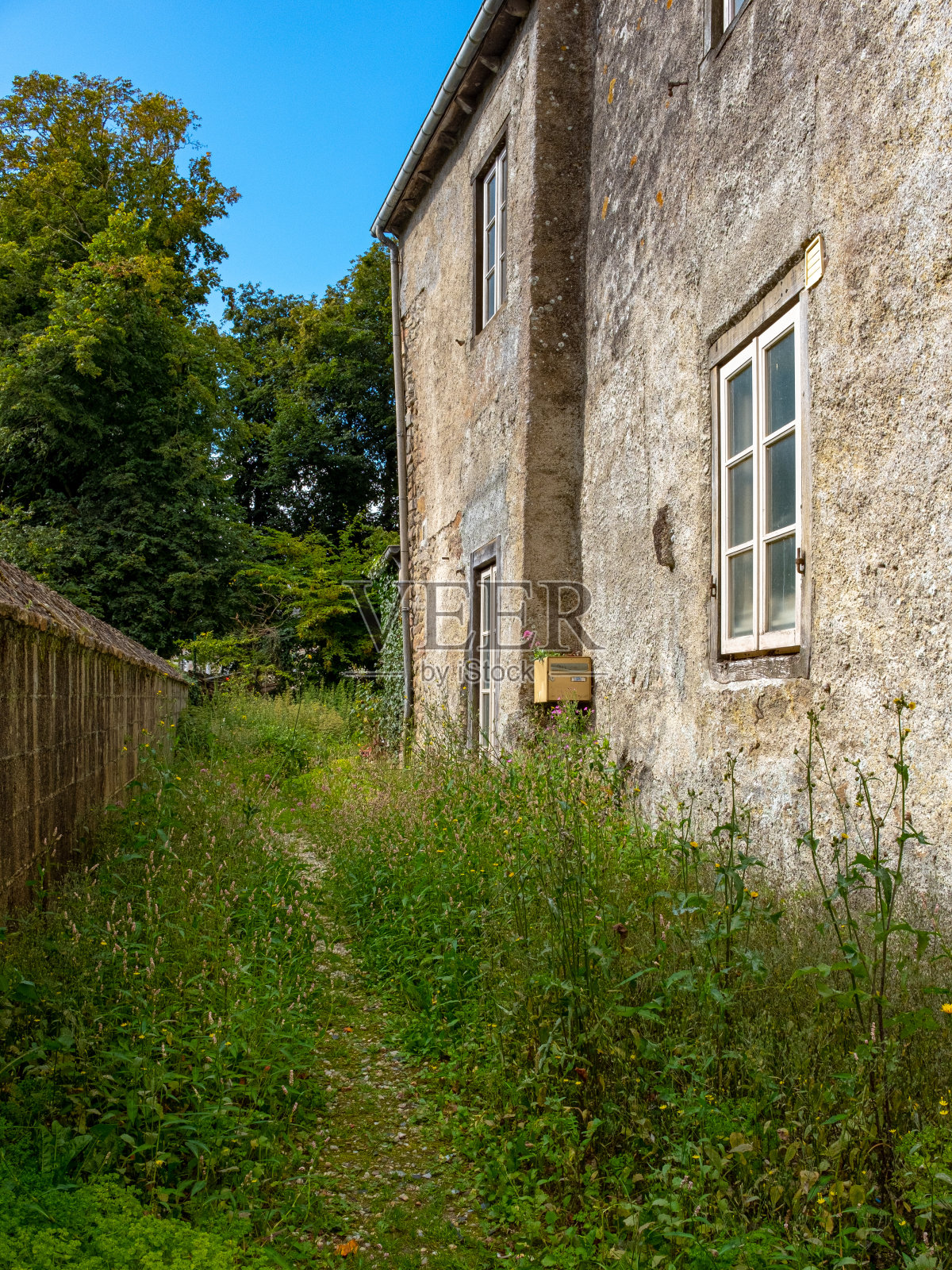 沿着一幢满是污垢的老房子的小路照片摄影图片