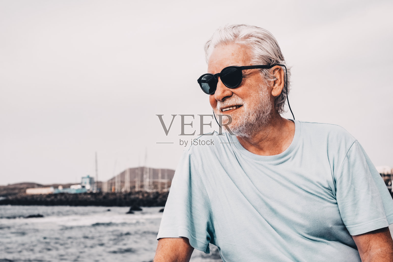 在日出的时候，坐在沙滩上，看着地平线，享受着自由和退休生活照片摄影图片