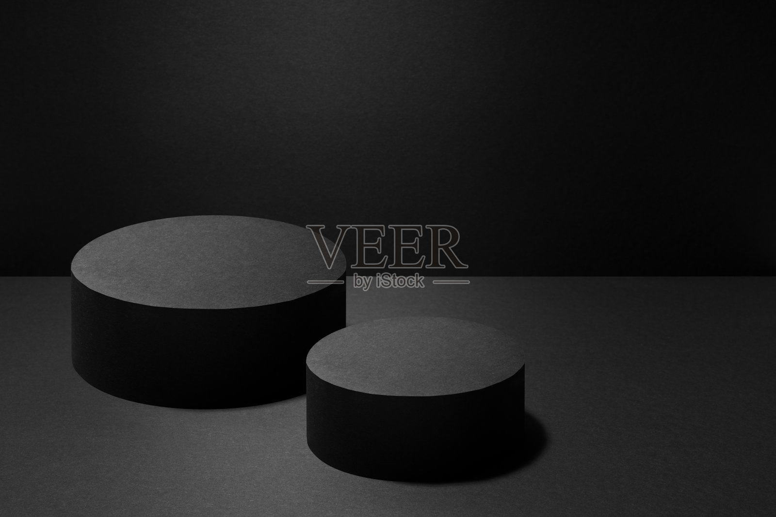 摘要:两个黑色的圆形讲台，用于化妆品，带有光束，黑色背景上的模型。现场展示产品、商品、广告、设计、展示、音乐会风格展示。照片摄影图片