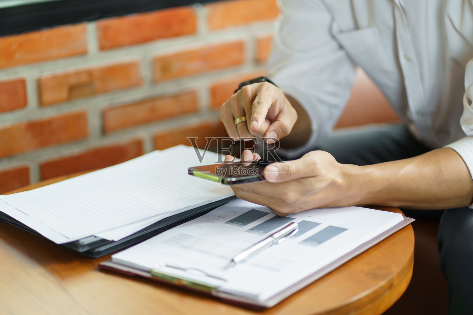 年轻的商人手持SmartphoneÂ工作移动设备。手机技术电子商务智能手机商务工作。照片摄影图片