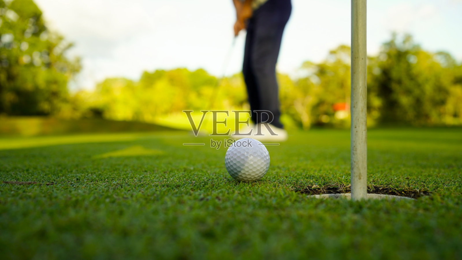 傍晚时分高尔夫球场上模糊的高尔夫球手照片摄影图片