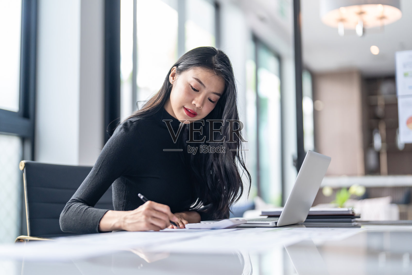 BeautifulÂ自信的亚洲商务女性用手提电脑打字键盘。专业投资人负责新启动项目。办公室业务规划。技术业务照片摄影图片