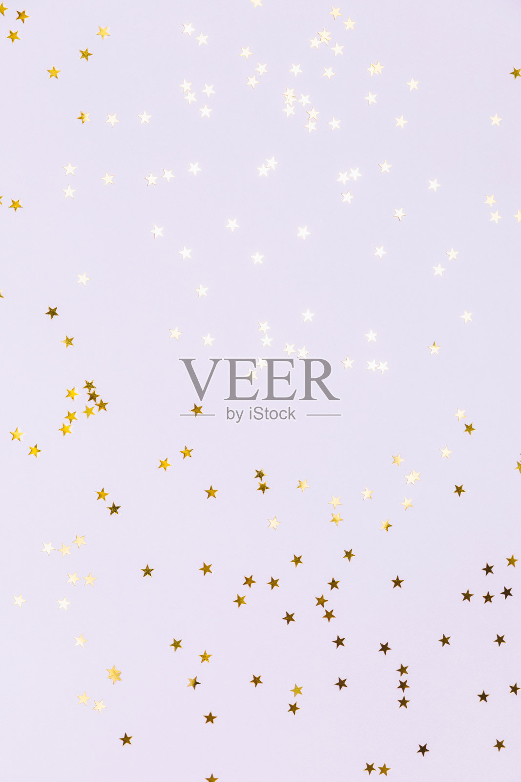 在淡紫色粉彩背景上闪耀着金色的星星。闪闪发光，闪闪发光。圣诞佳节平铺，寒假，新年，生日快乐概念。平铺，俯视图，复制空间。照片摄影图片