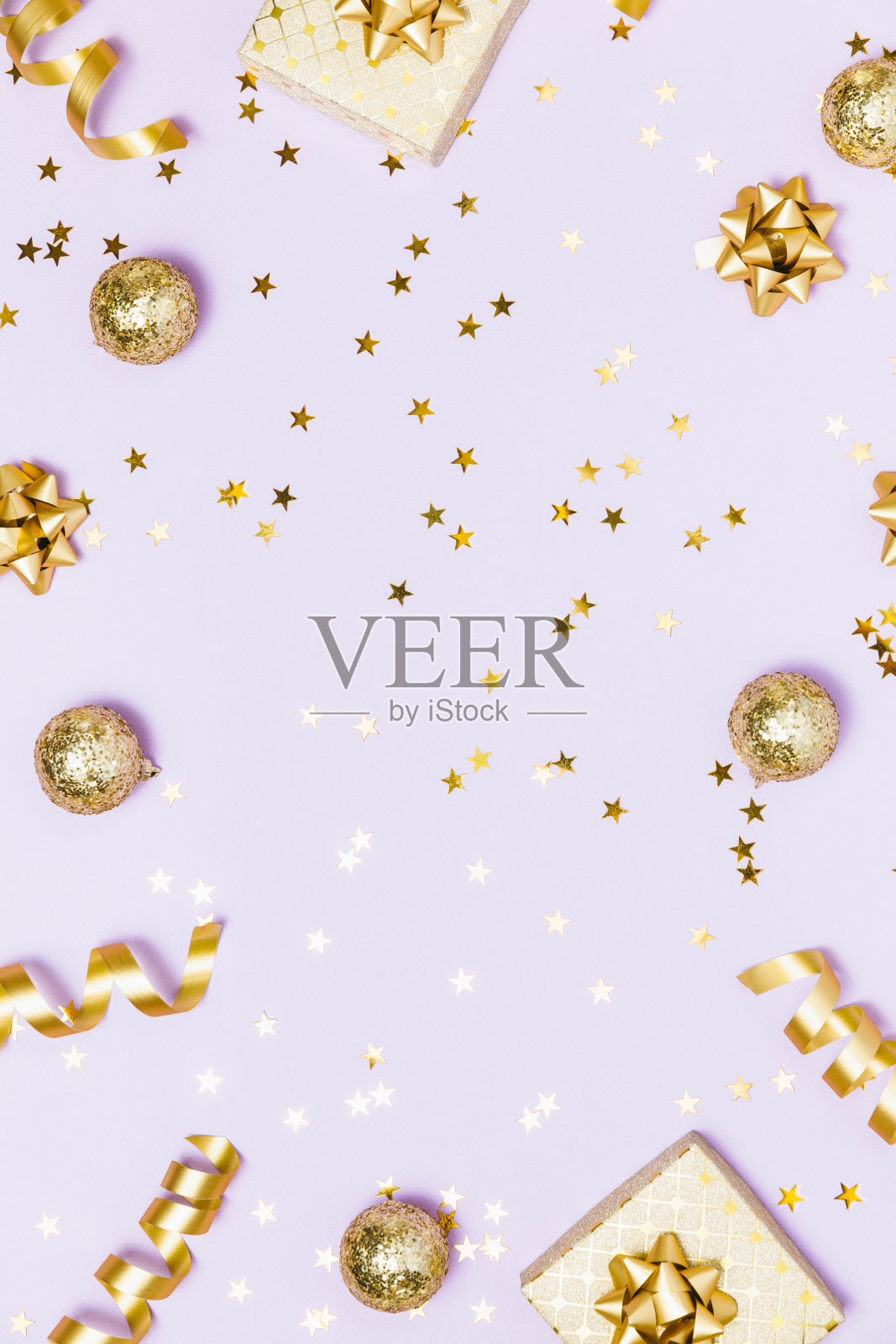 圣诞边框构图平铺。金色的派对装饰品，五彩纸屑，薰衣草背景的礼物。圣诞节、寒假、新年的概念。俯视图，复制空间。照片摄影图片