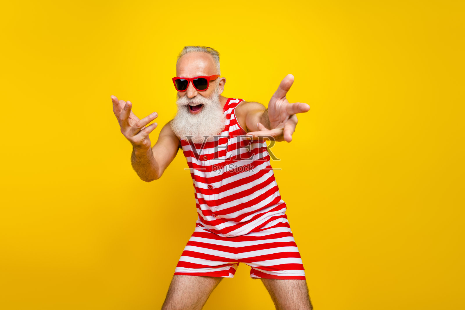 照片积极的好心情高级男子穿着红色条纹泳衣有乐趣的海滩迪斯科孤立的黄色背景照片摄影图片