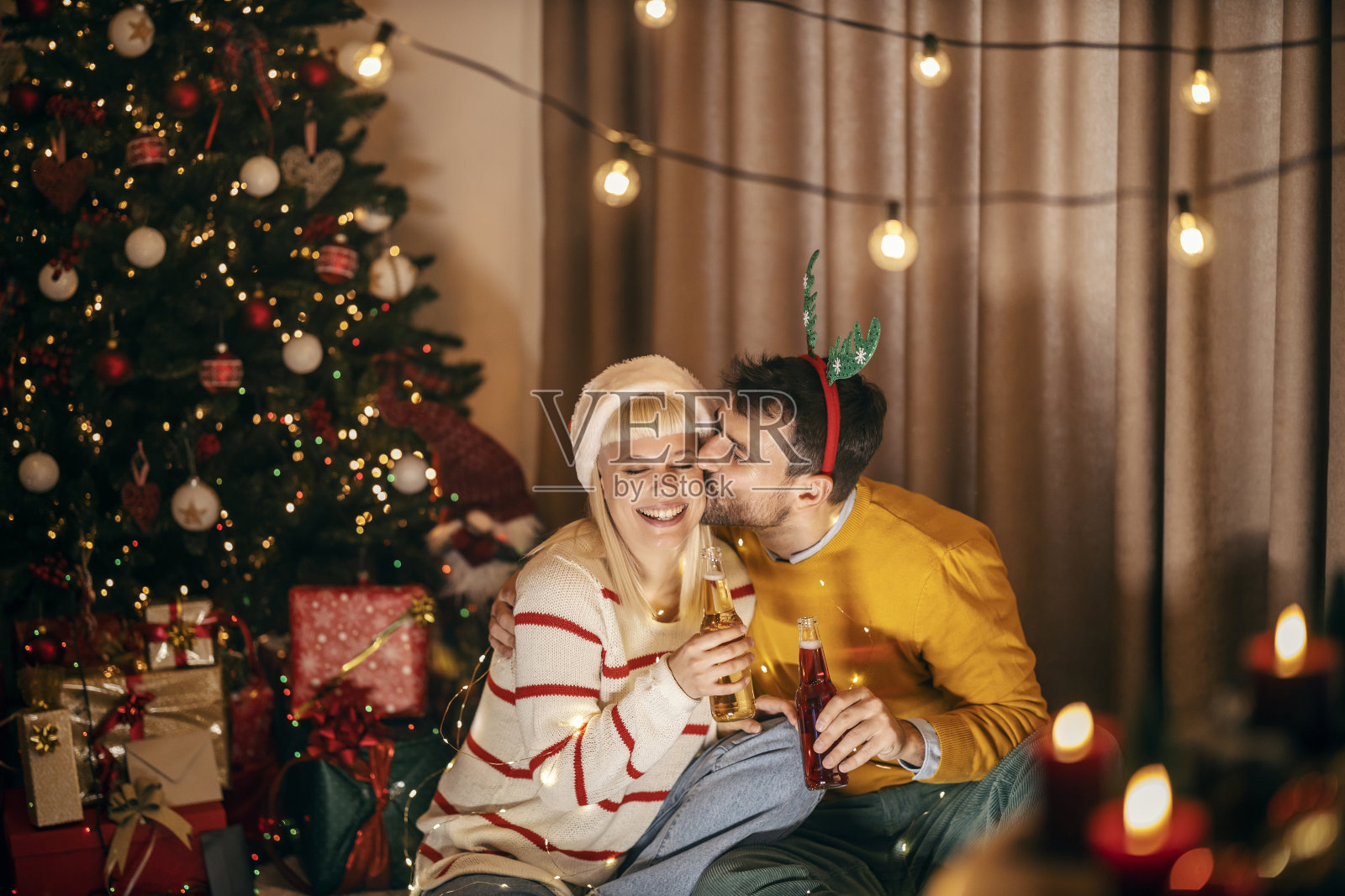 圣诞夜和除夕，一对幸福的夫妇在家里亲吻，举杯庆祝。照片摄影图片