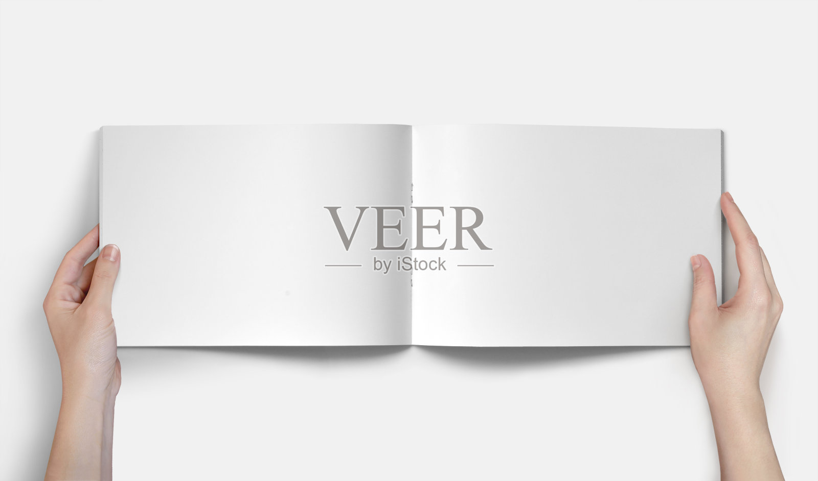 手持水平A4小册子模型在一个白色的背景照片摄影图片