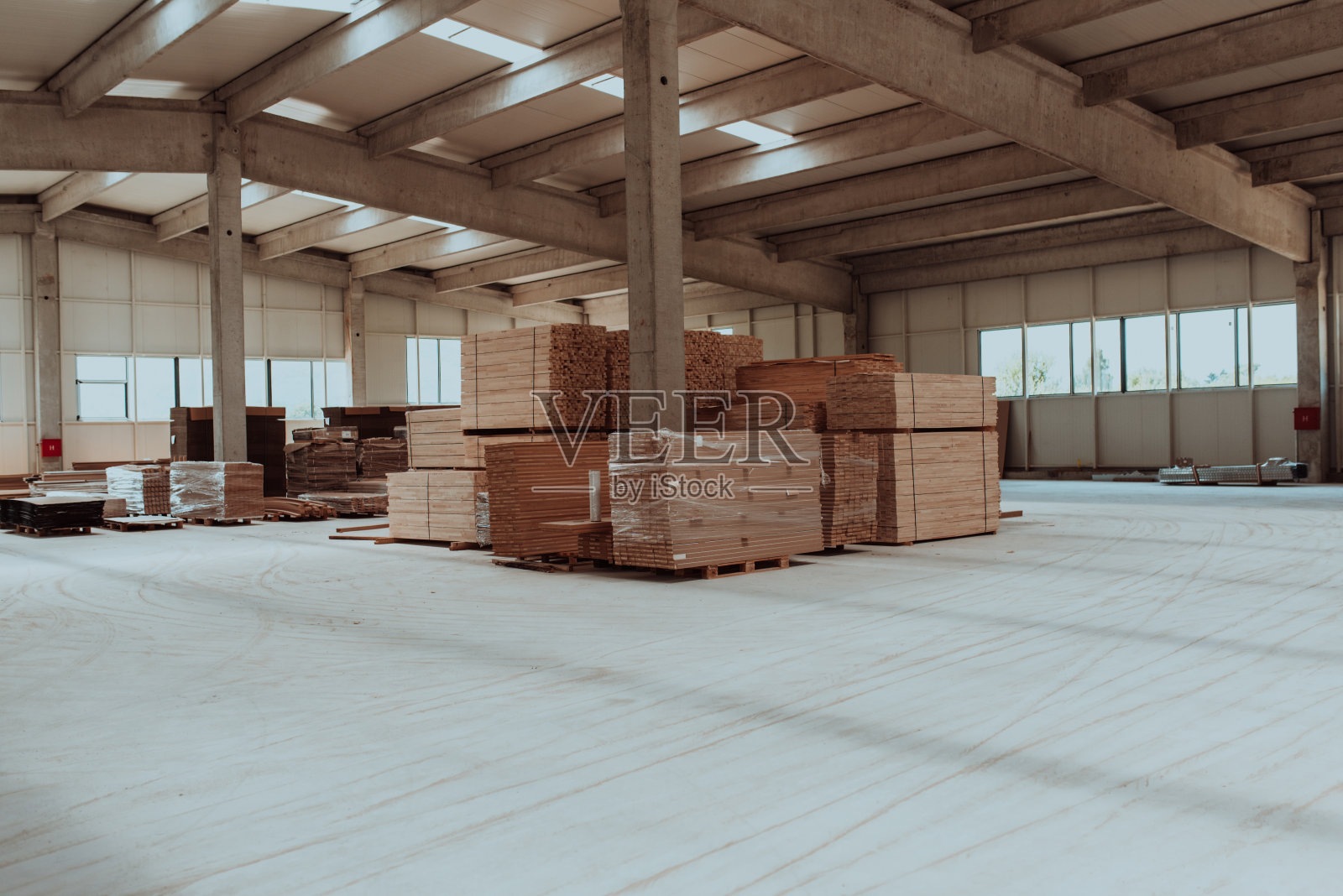 这是一个巨大的林业仓库，展示了大量的木制品，包括木板和各种木材物品，整齐地摆放在仓库里照片摄影图片