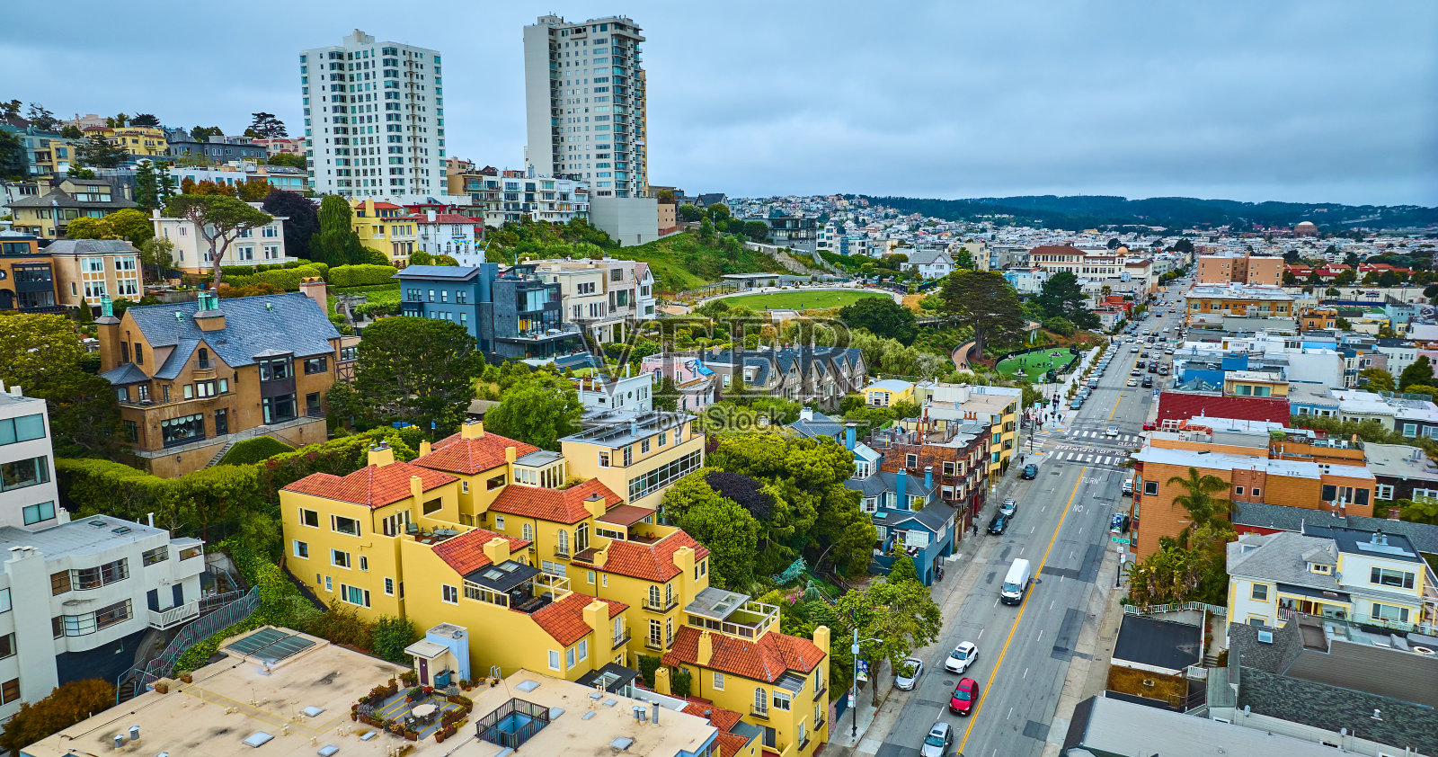 明亮的黄色公寓大楼旁边的长旧金山城市街道架空，加州照片摄影图片