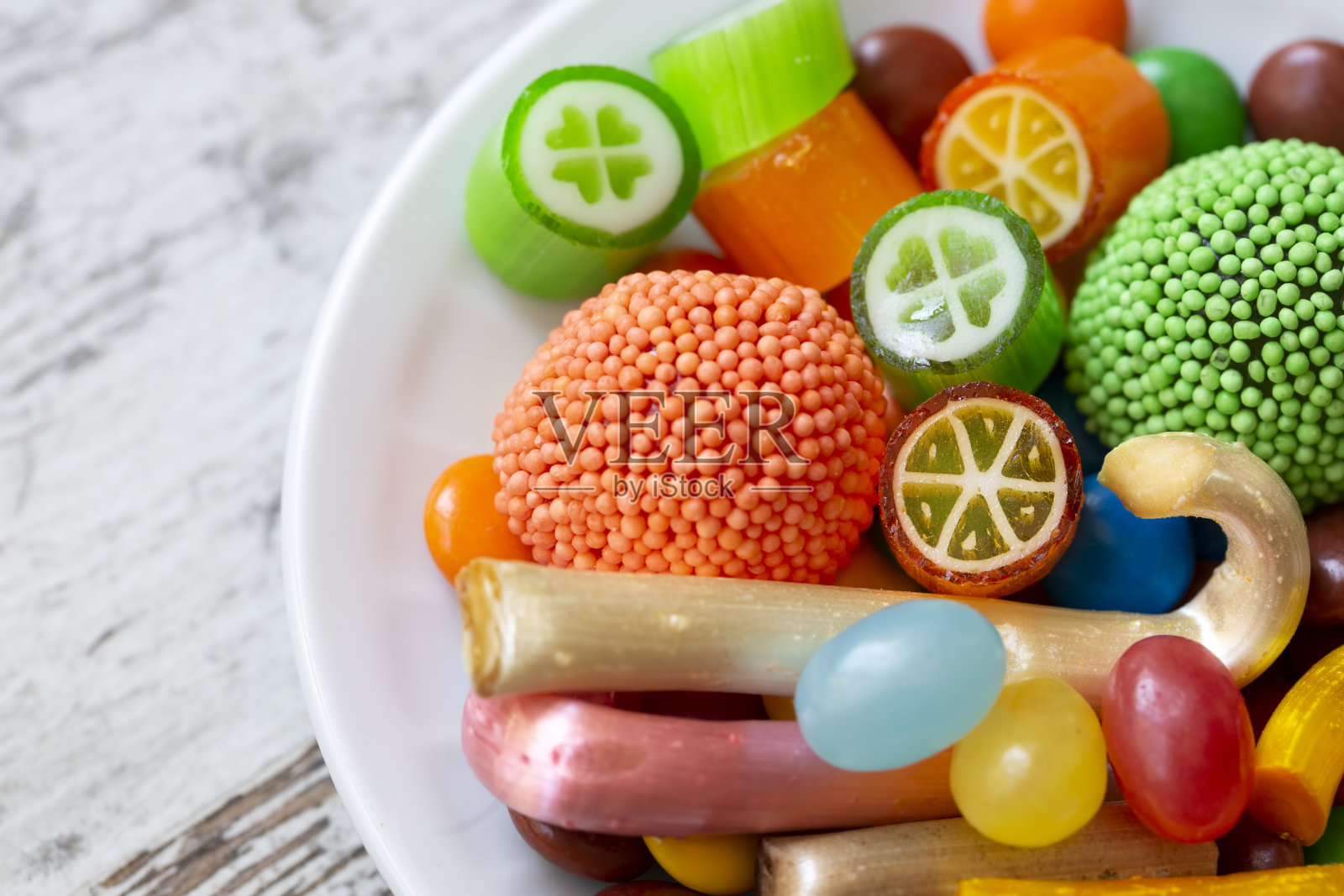 五颜六色的棒棒糖和不同颜色的圆糖。前视图。照片摄影图片