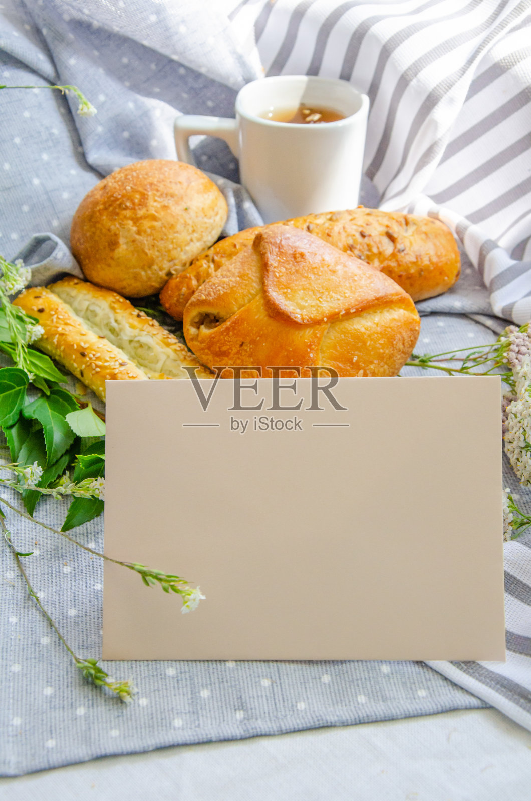 空卡片和美味的早餐和一杯茶在棉桌布。模拟，复制空间。垂直的构图。照片摄影图片