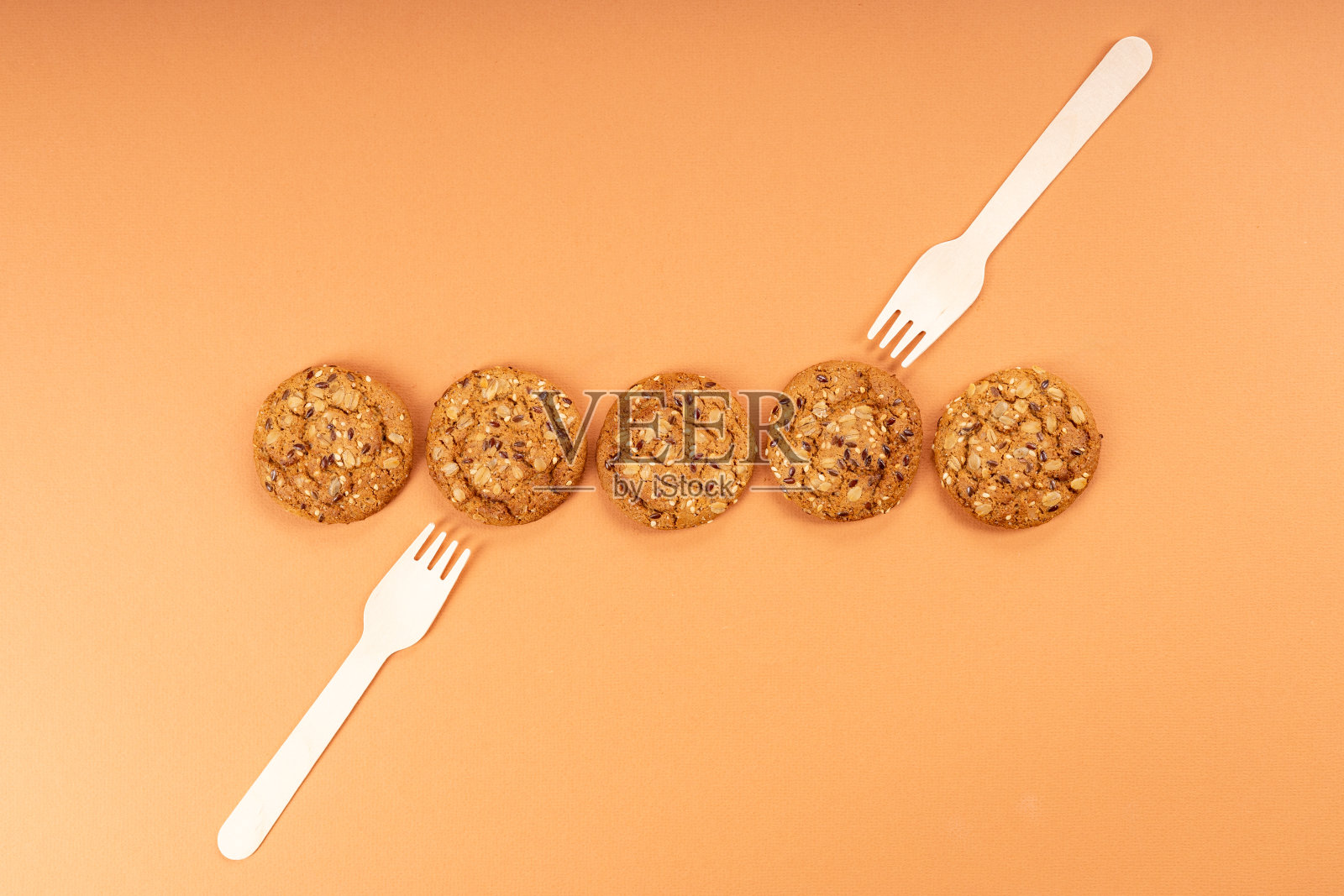 五块燕麦饼干排成一排，一把叉子放在饼干上面，另一把叉子从下面插进饼干里照片摄影图片