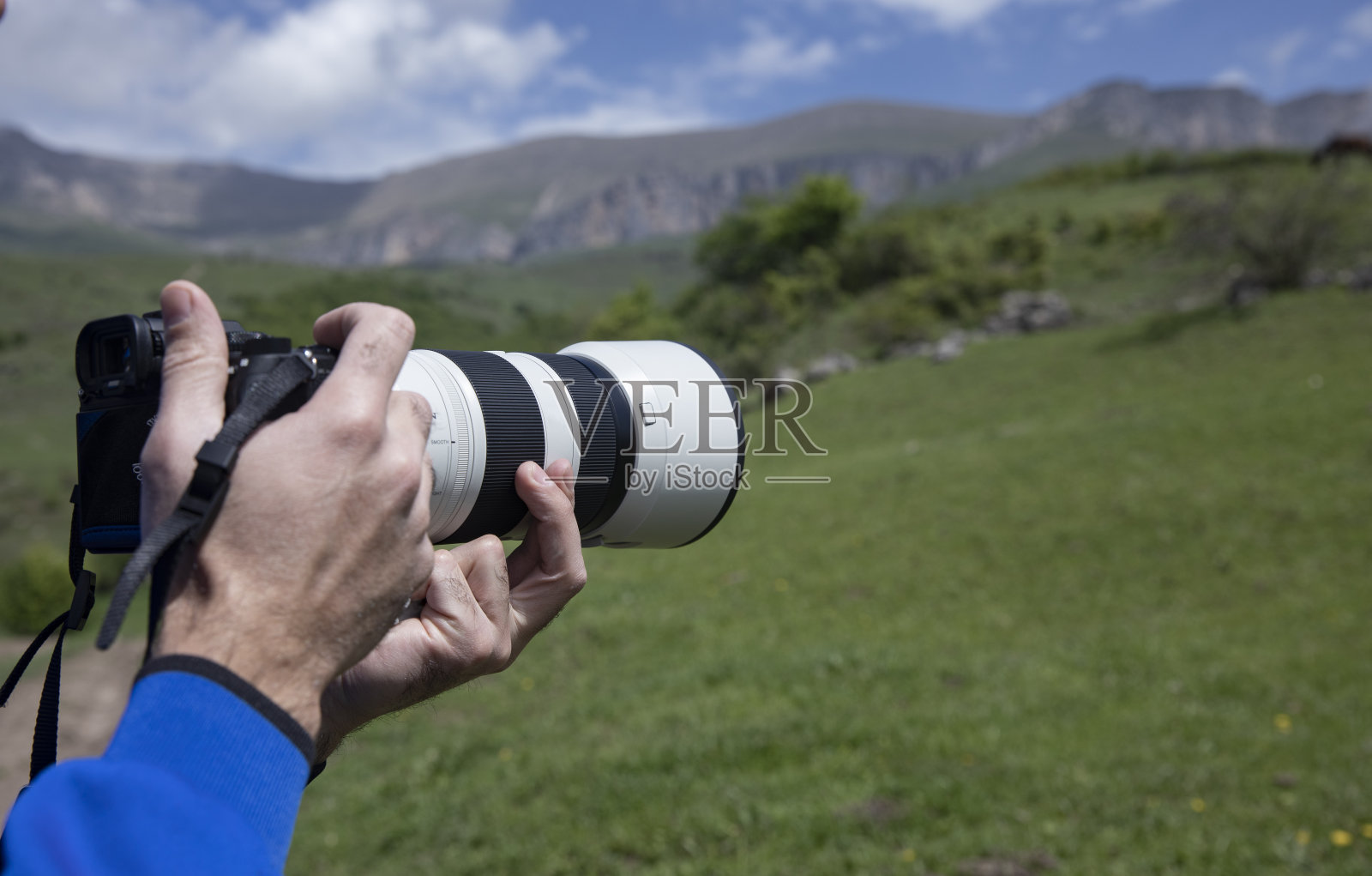 手持相机的专业摄影师在户外照片摄影图片