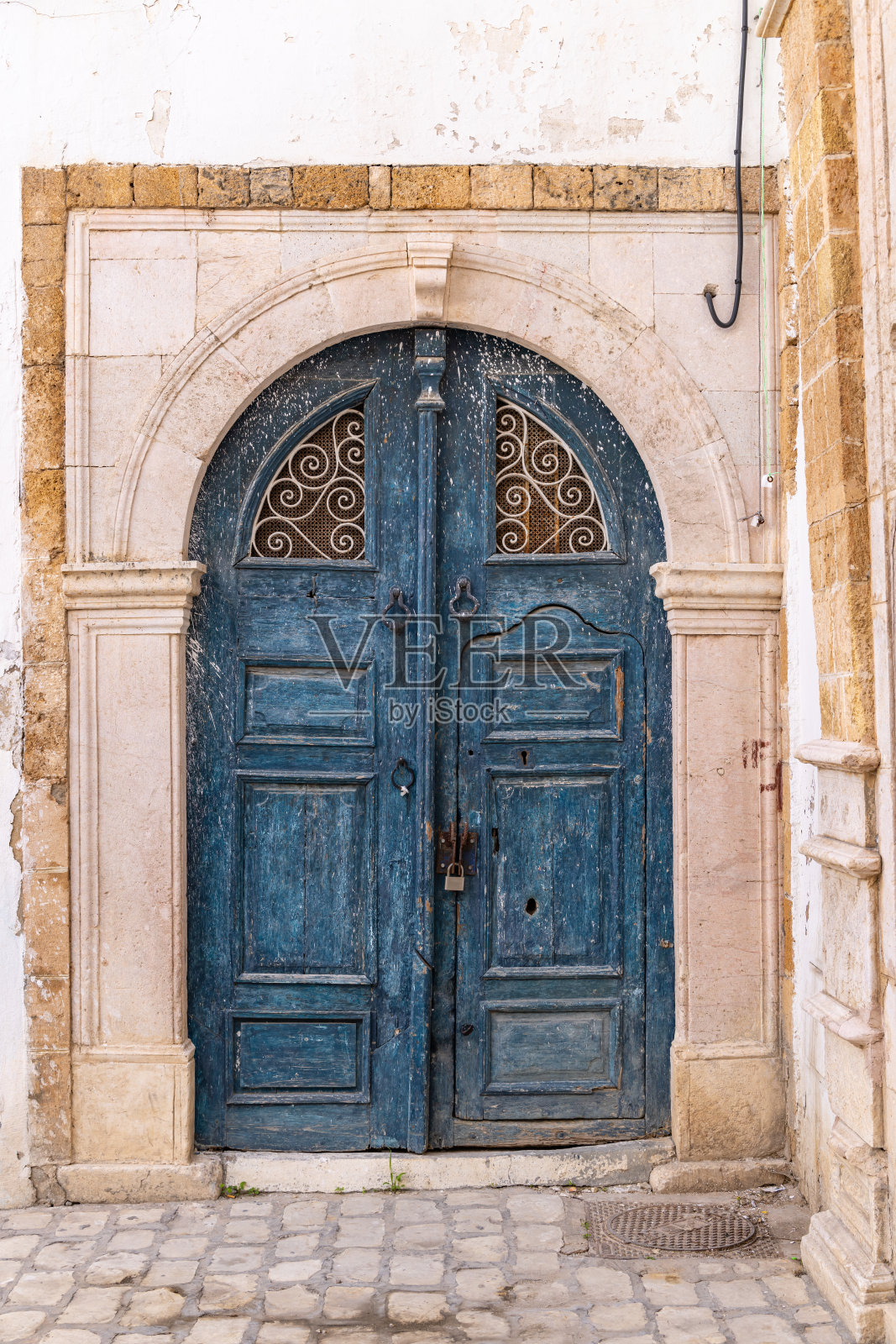 突尼斯露天市场附近一所房子上的蓝色锁眼或摩尔式拱门。照片摄影图片