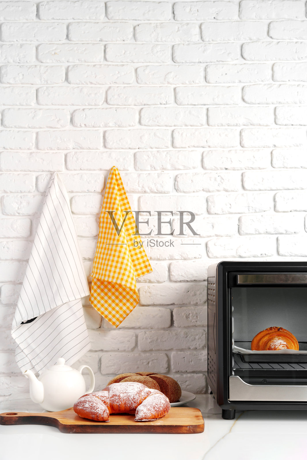 厨房配有新鲜出炉的羊角面包的现代迷你电烤箱照片摄影图片