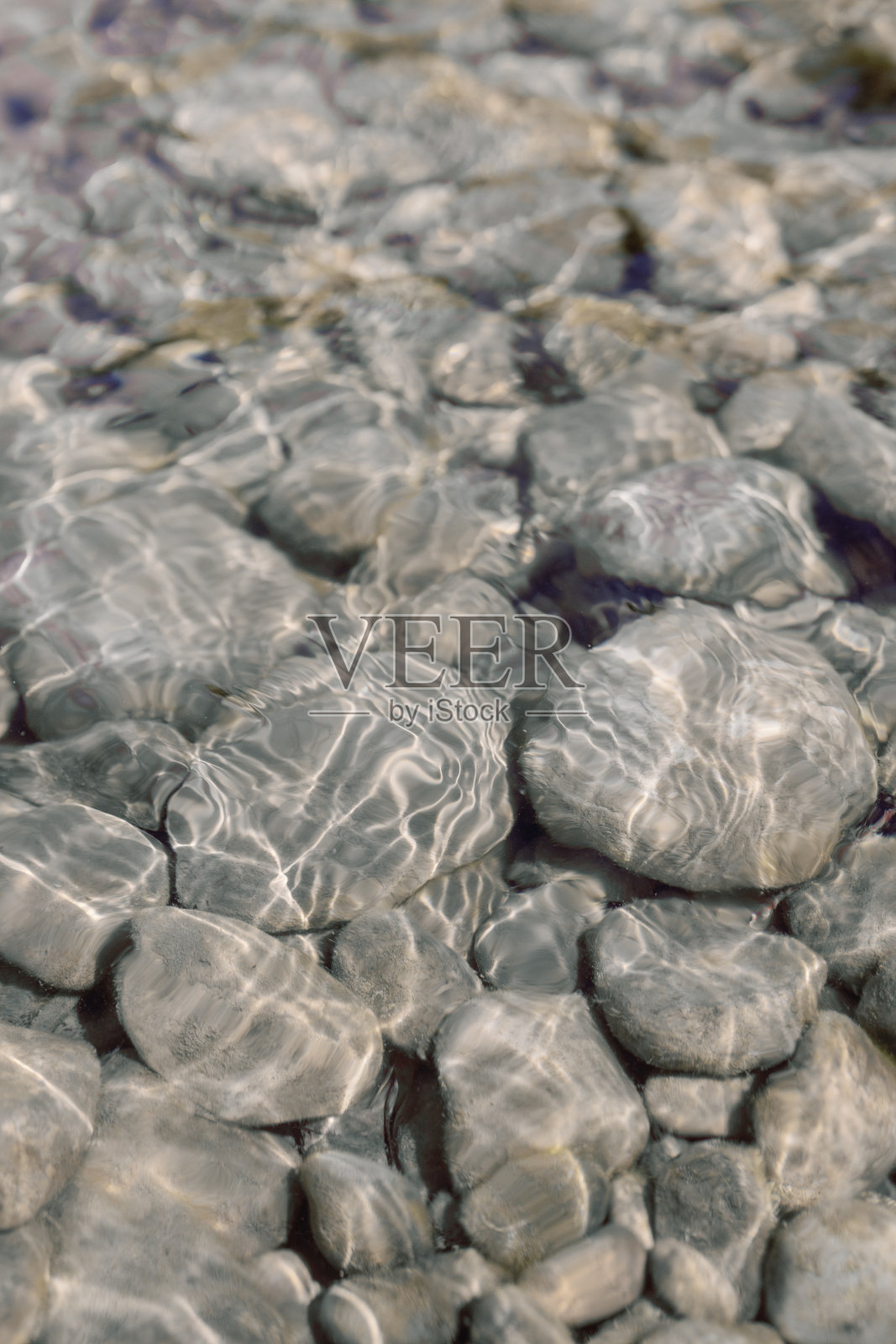 岩石在平静清澈的河水的阳光下闪闪发光照片摄影图片